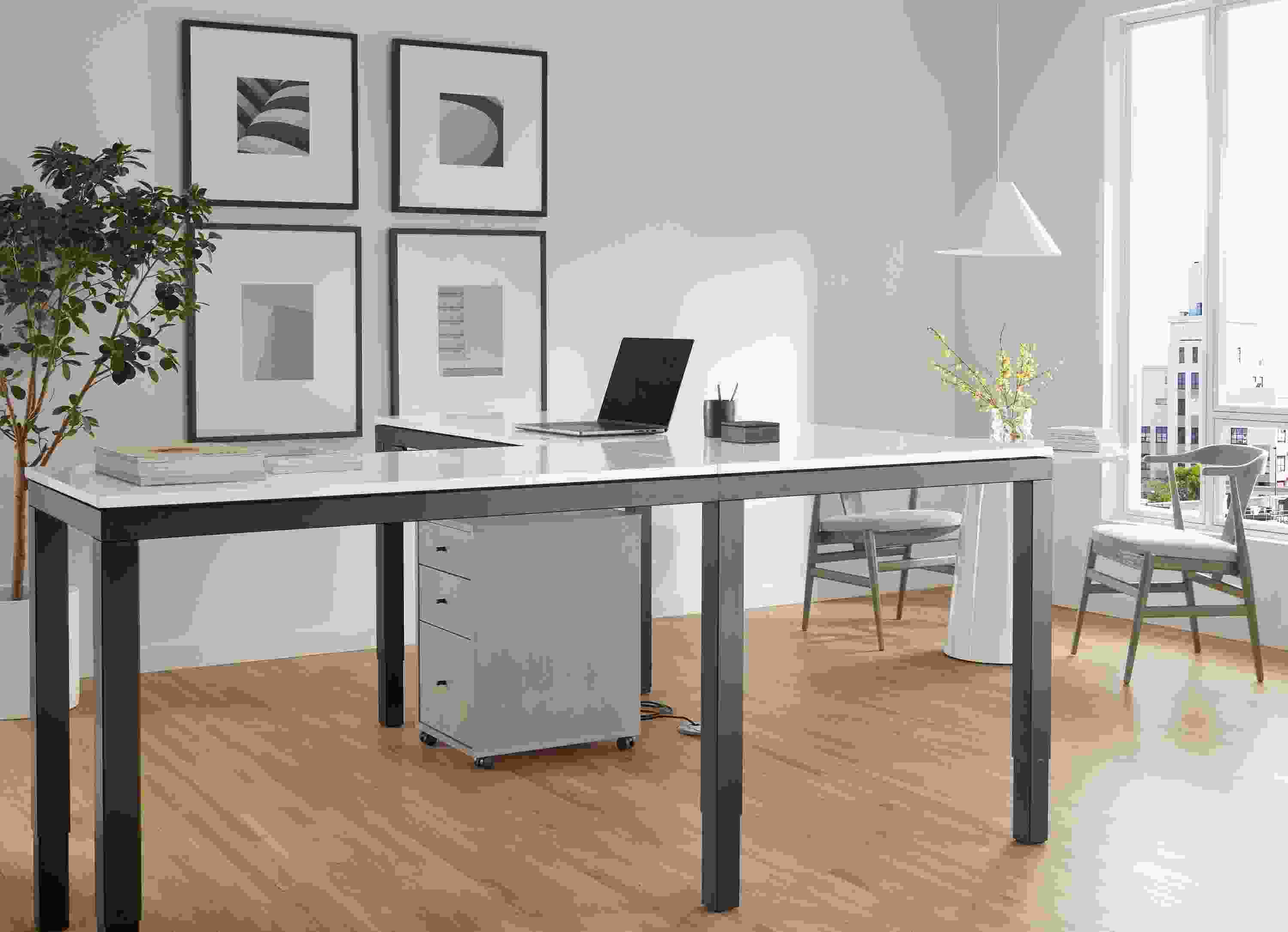 Office area with Parsons Adjustable height standing desk in graphite and light grey quartz top in standing position with sequel file cabinet in shell.