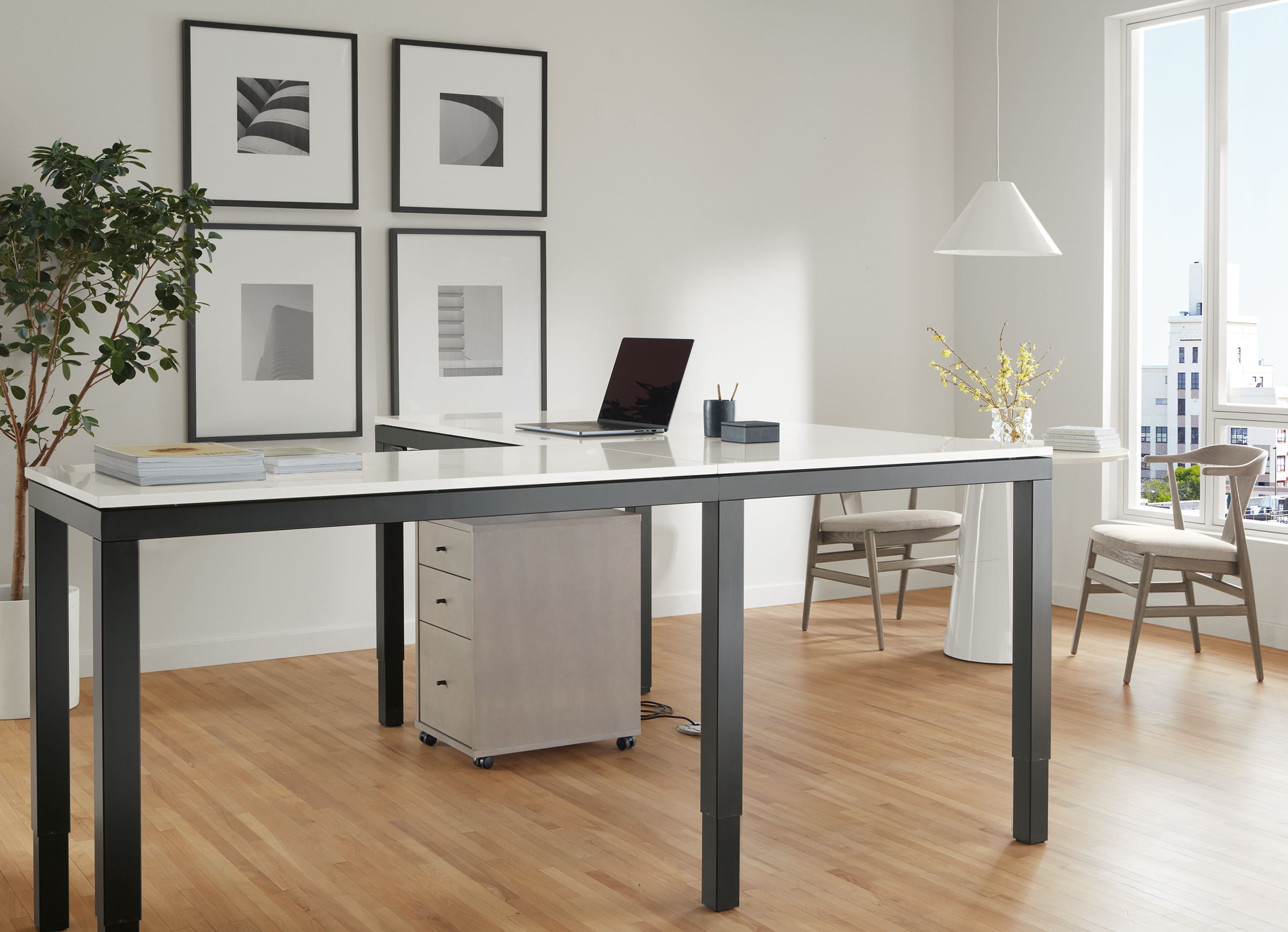 Office area with Parsons Adjustable height standing desk in graphite and light grey quartz top in standing position with sequel file cabinet in shell.