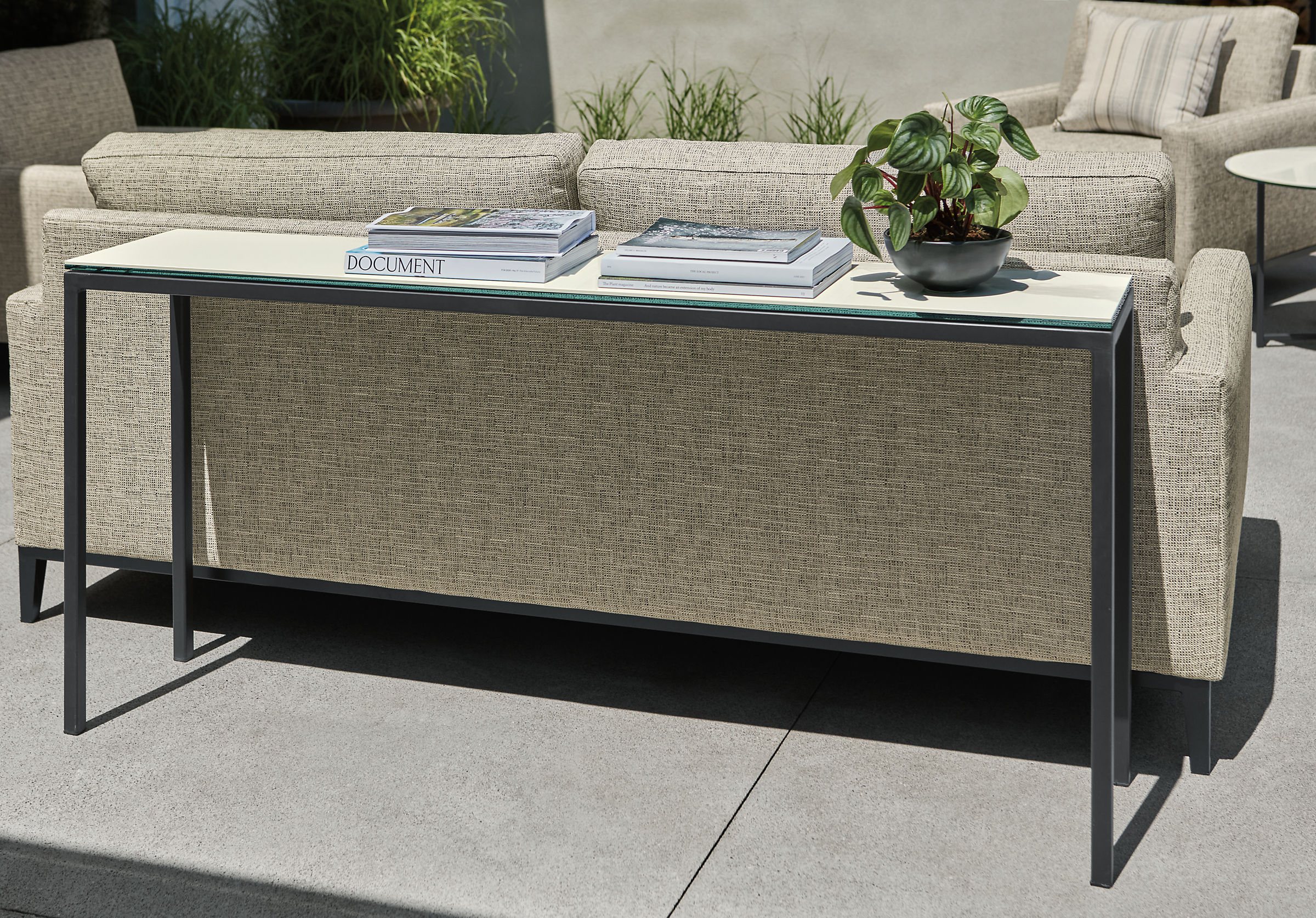 Parsons 60w 12d outdoor console table in graphite with marbled white ceramic top and Tomas sofa and chairs.