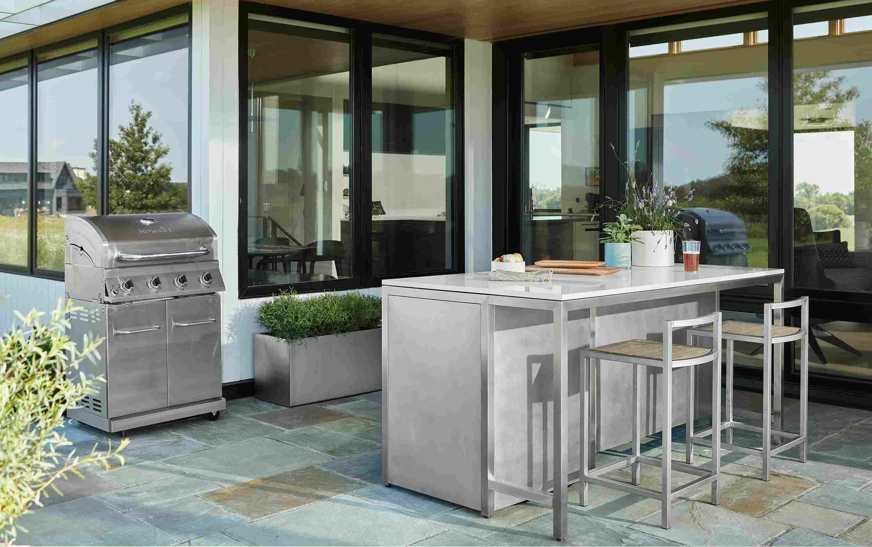 Patio with parsons outdoor counter table in stainless with marbled white quartz top.