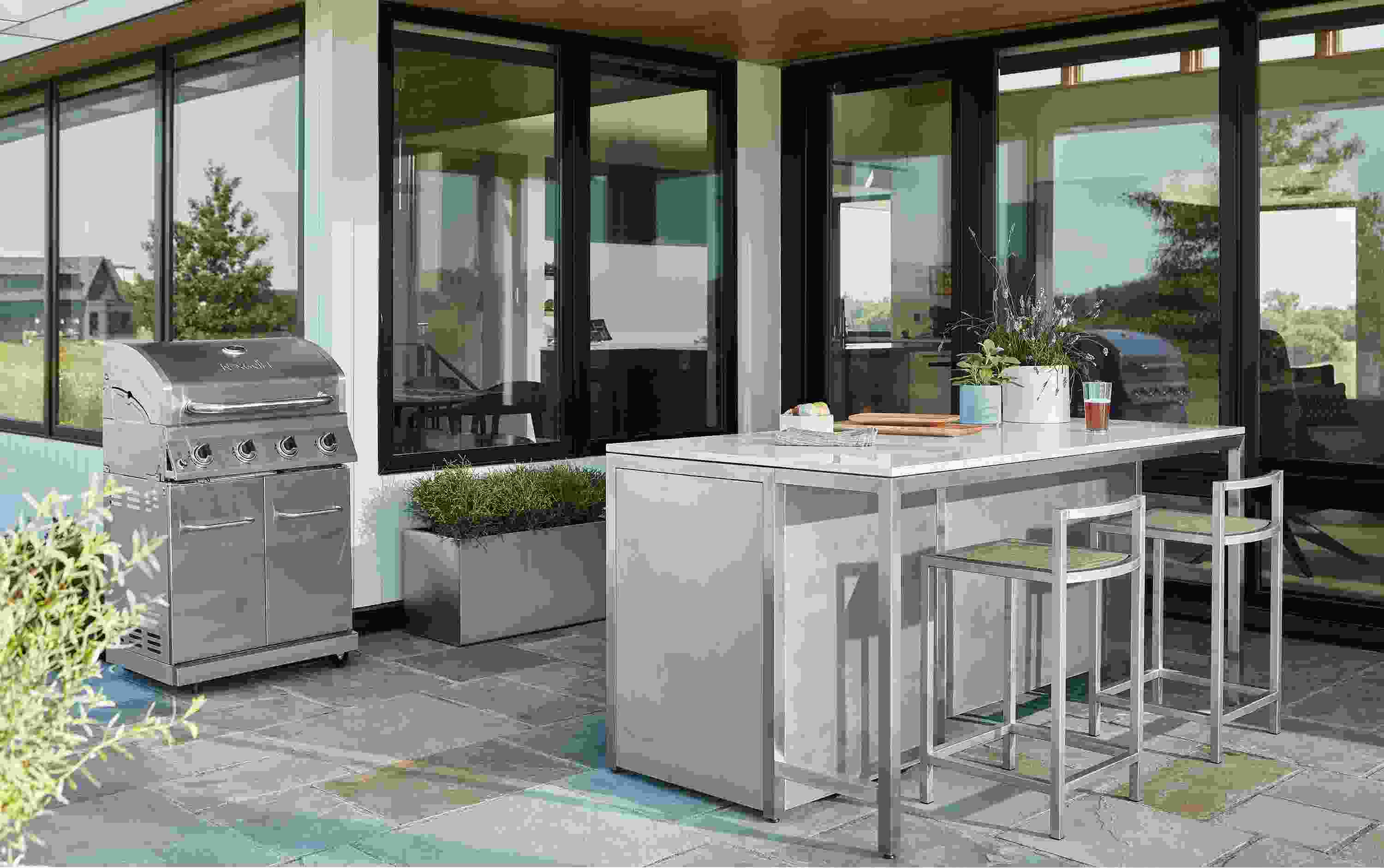 Patio with parsons outdoor counter table in stainless with marbled white quartz top.