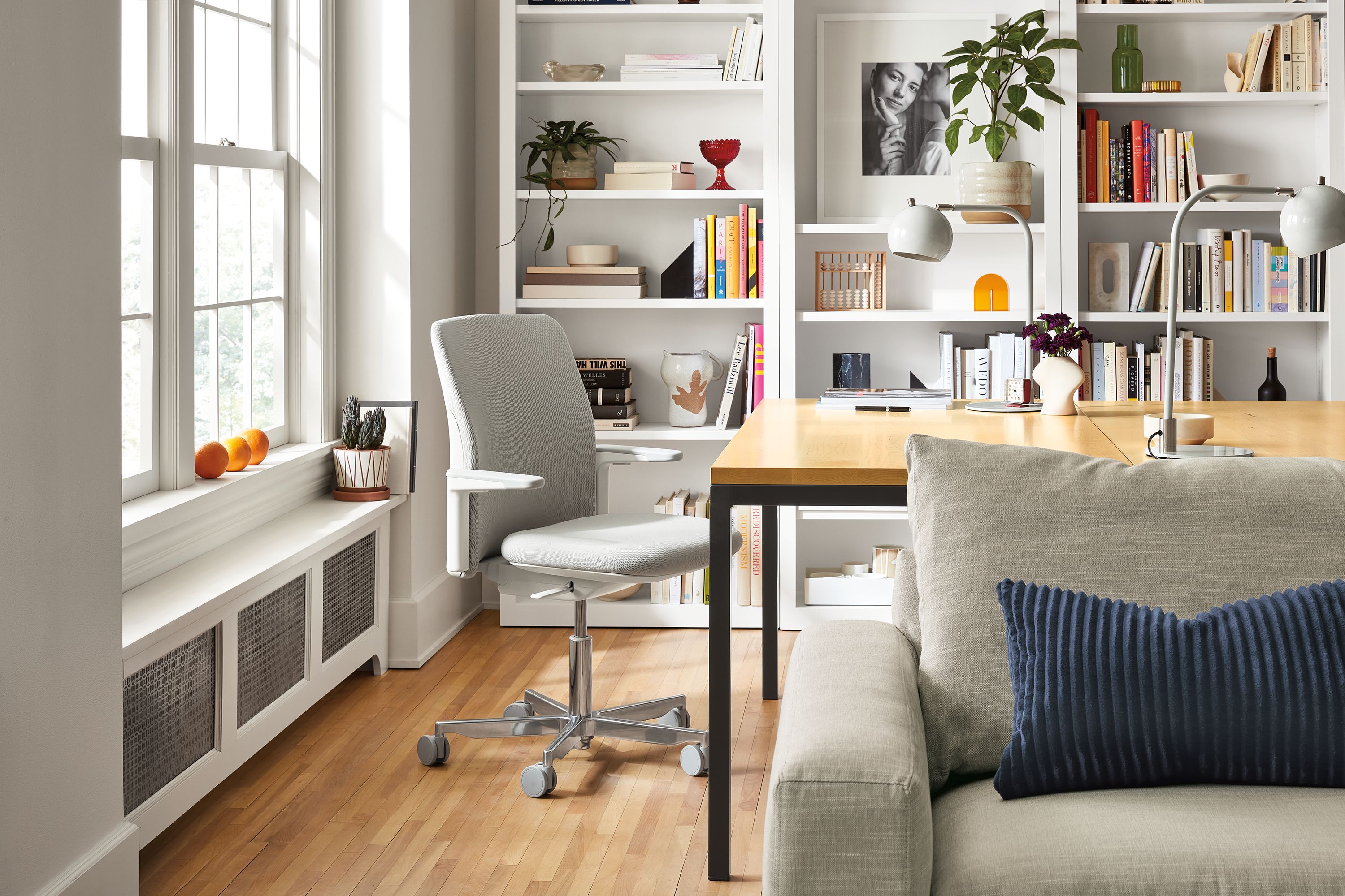 room setting including path office chair, parsons table, woodwind bookcases, metro sofa.