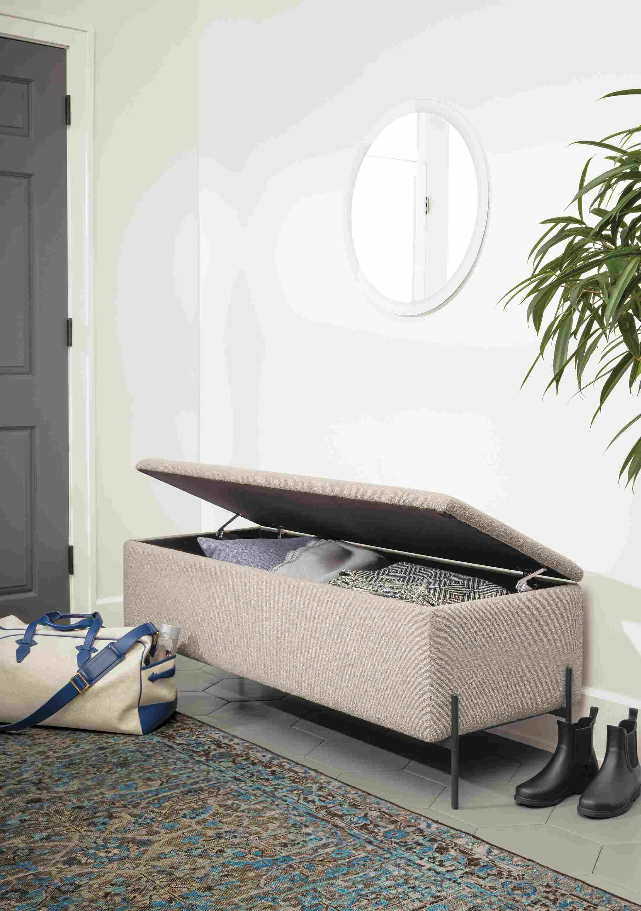 Detail of Paxton storage ottoman in Declan Salt fabric in entryway with storage lid open.