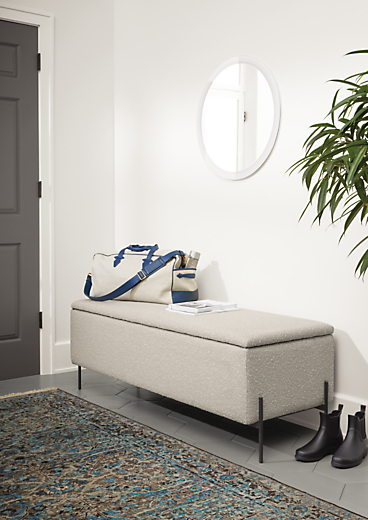 Detail of Paxton storage ottoman in Declan Salt fabric in entryway with blue rug.