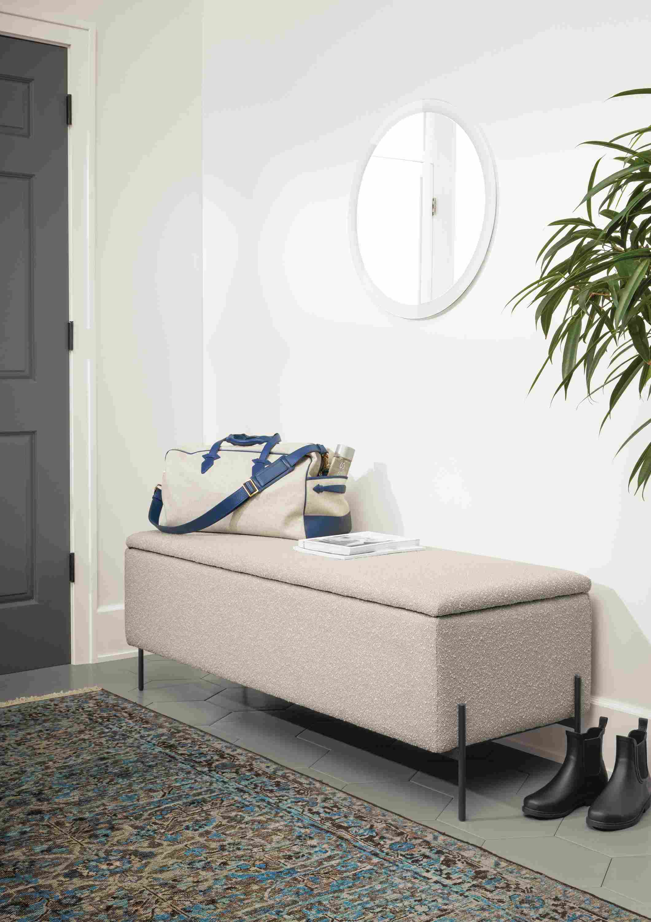 Detail of Paxton storage ottoman in Declan Salt fabric in entryway with blue rug.