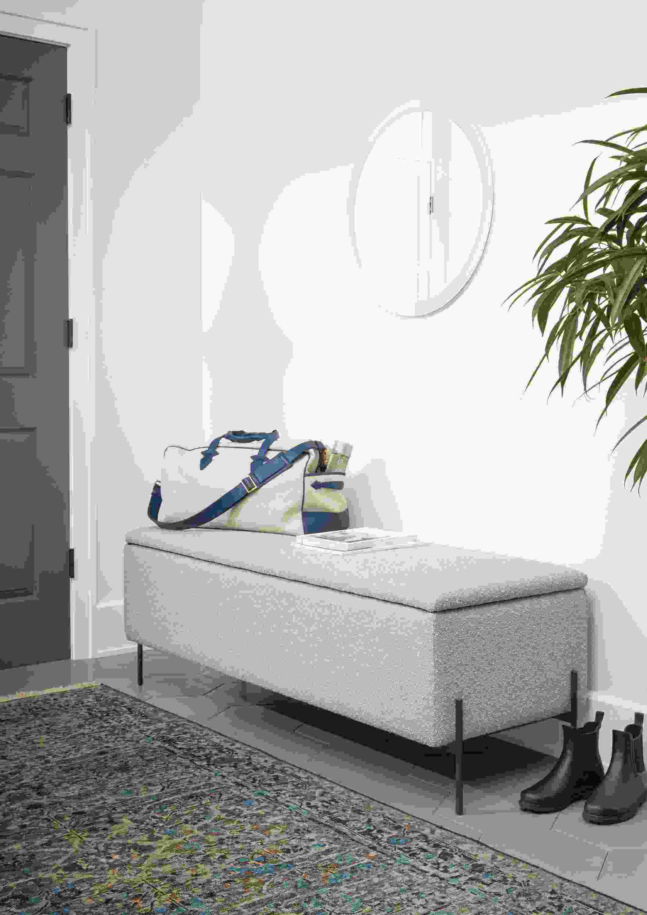 Detail of Paxton storage ottoman in Declan Salt fabric in entryway with blue rug.