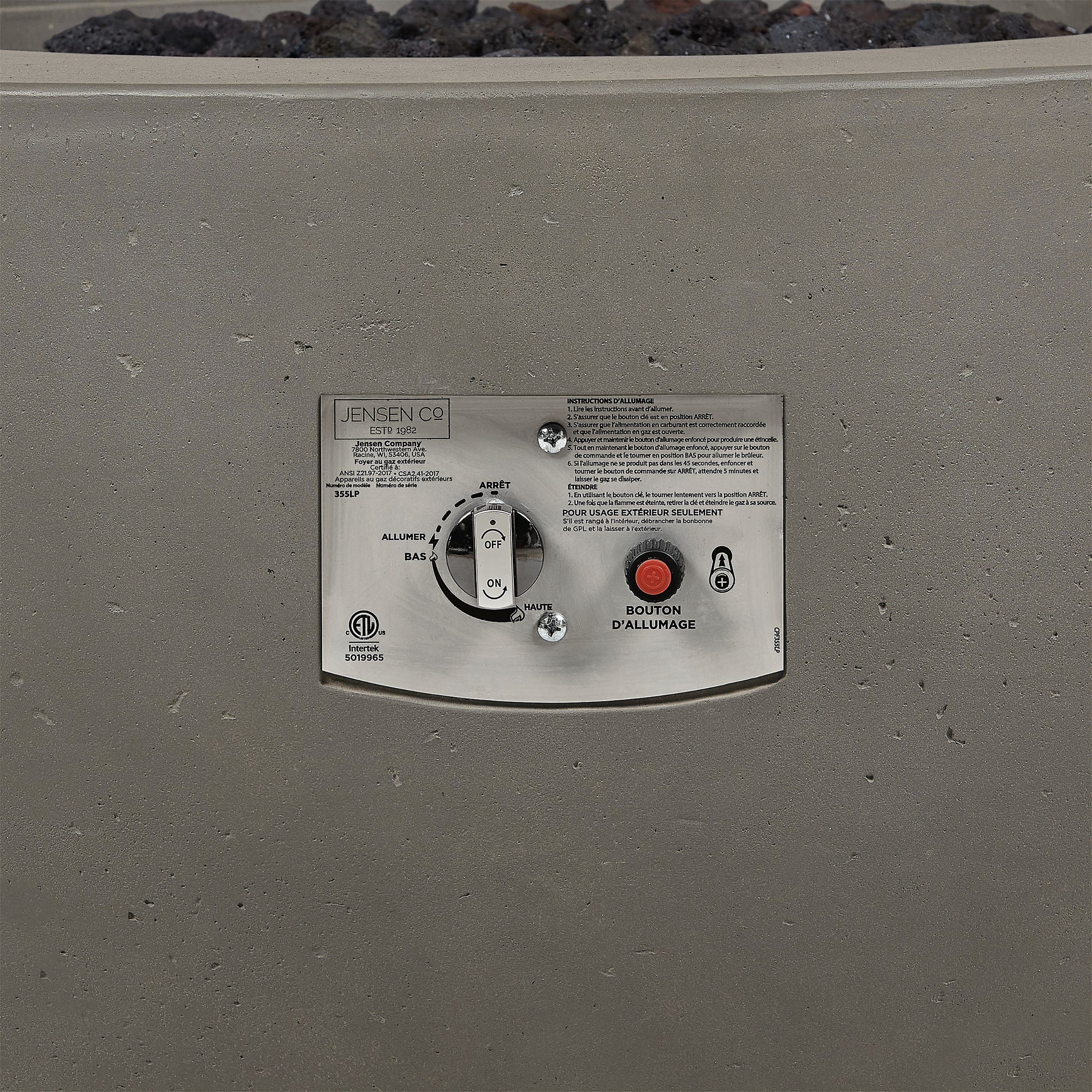 Detail of Pele 44-diameter outdoor propane fire table in grey concrete showing flame control knob and ignitor.