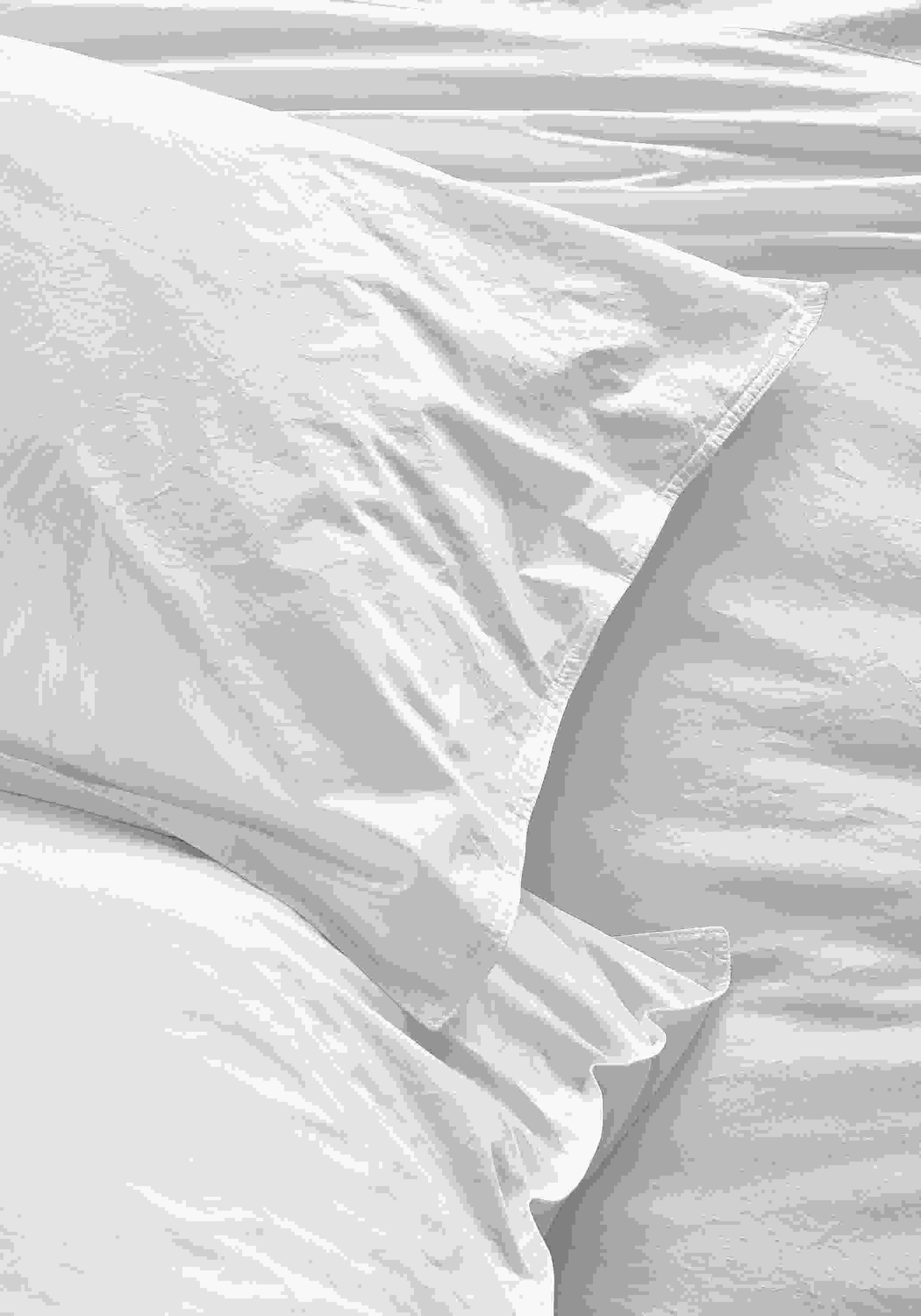 Detail view of Signature Percale standard sham and fitted sheet in white.