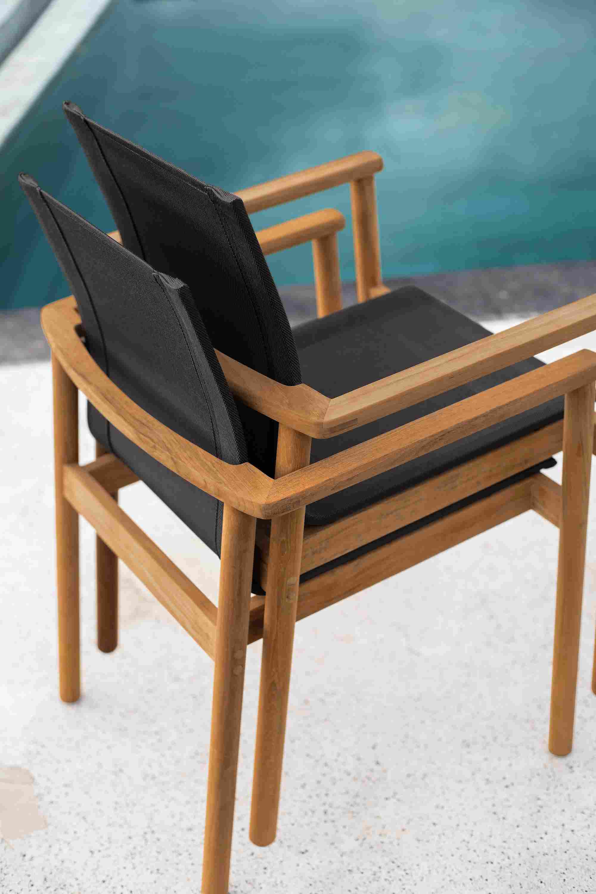 Stacked detail of two Peri Arm Chair in Teak with Slate Sling.