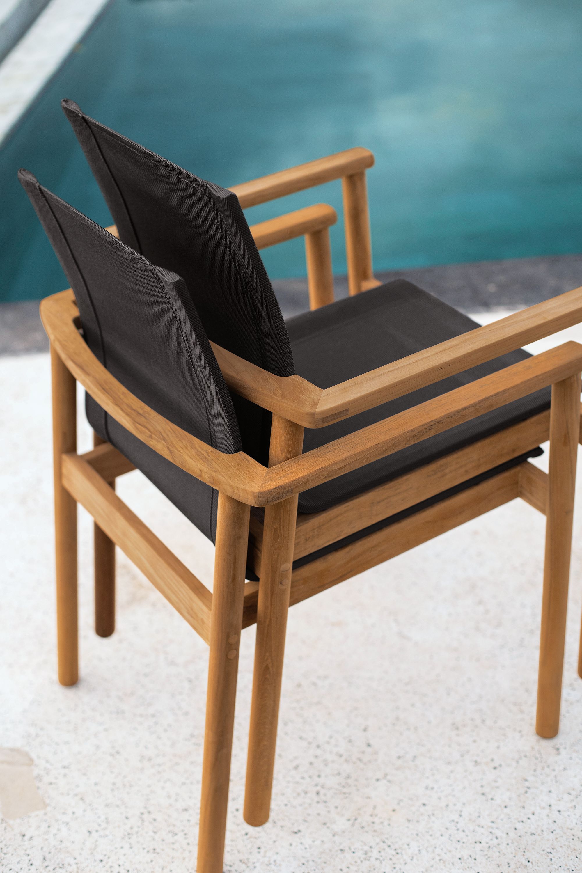 Stacked detail of two Peri Arm Chair in Teak with Slate Sling.