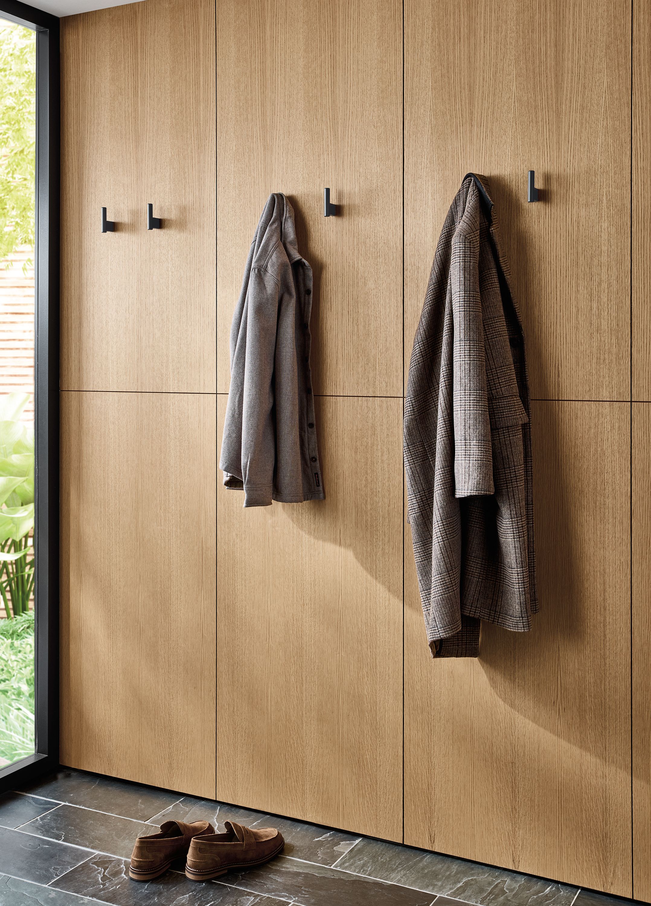 Sunny entryway with coats hanging on Pier wall hooks in graphite.