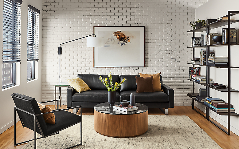 Living room setting with Pierson 89-inch sofa in urbino leather with liam 36-diam coffee table.