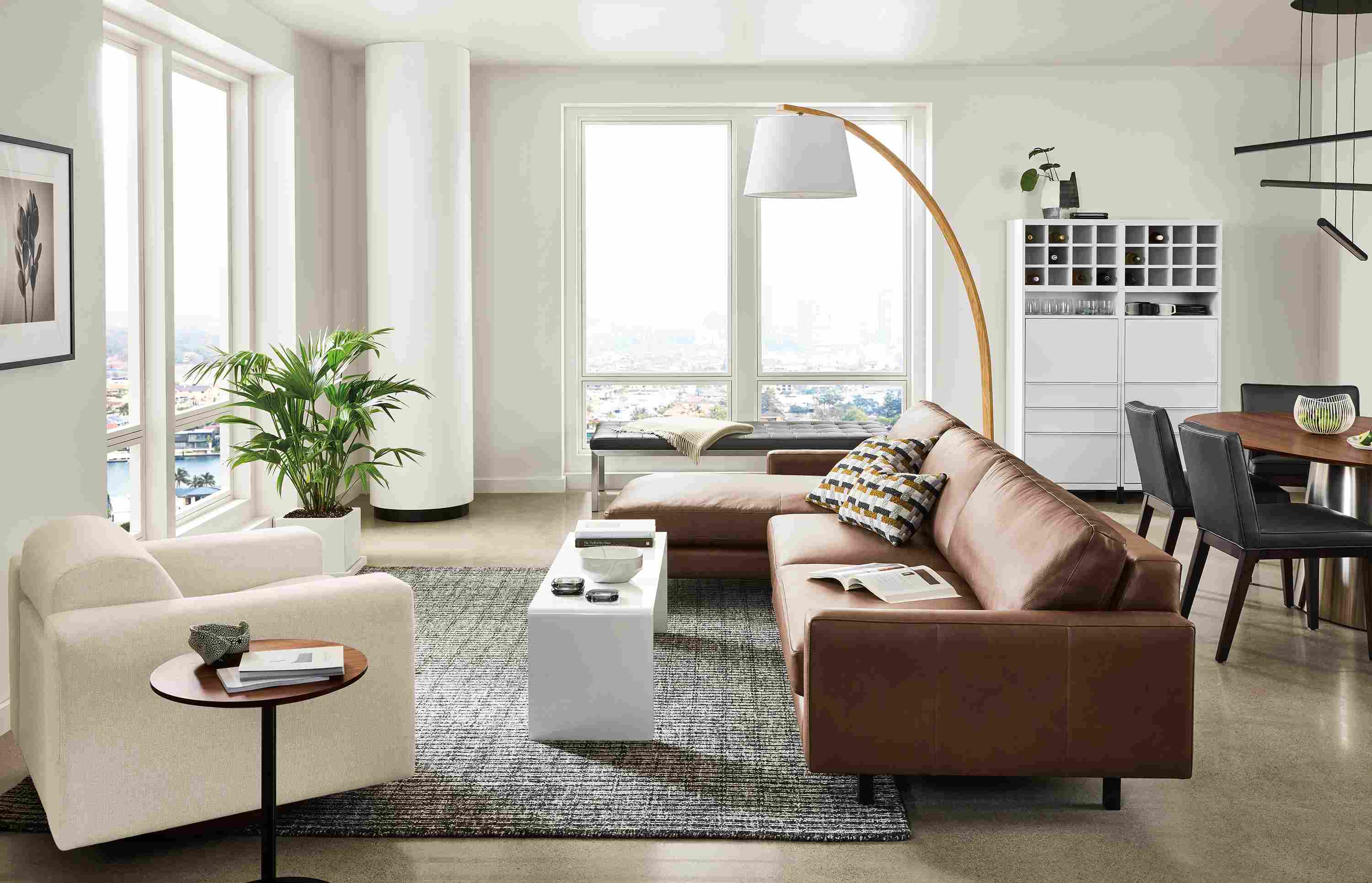 Large apartment living room with pierson sofa in laino cognac leather and harmon chair in tepic ivory.