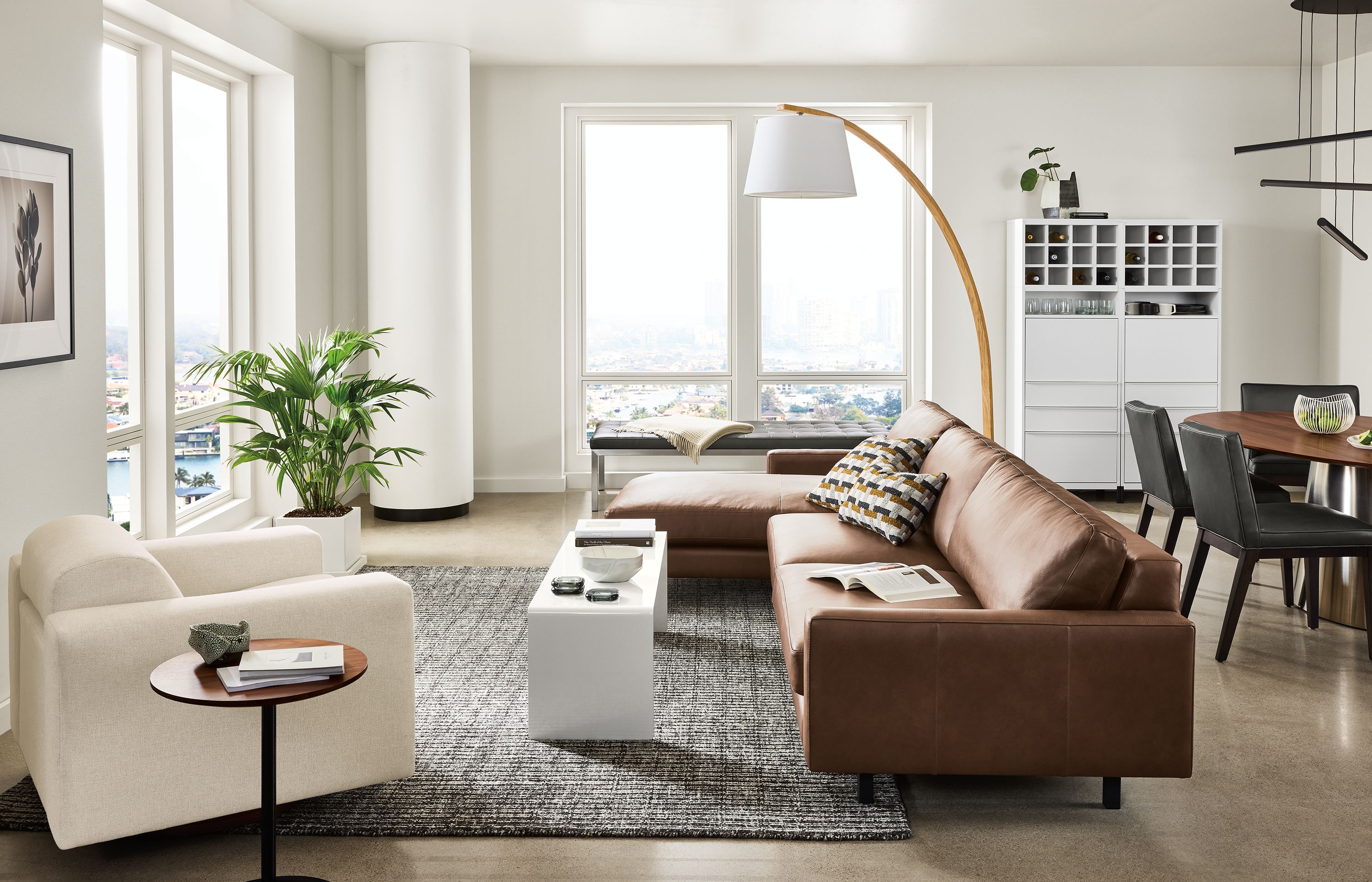 Large apartment living room with pierson sofa in laino cognac leather and harmon chair in tepic ivory.