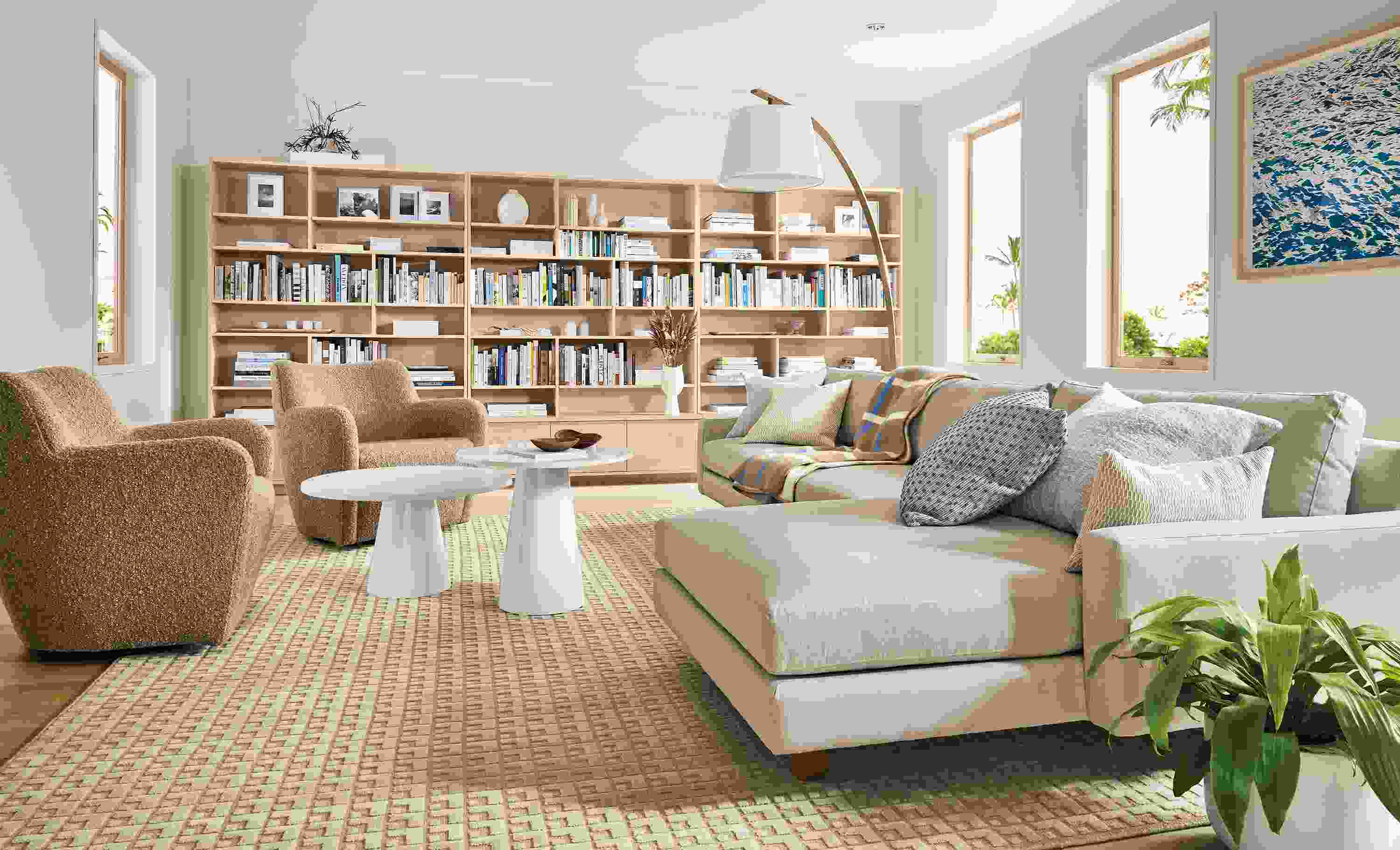 Living room with pierson sofa with chaise in Hines oatmeal, two lily chairs in dornick camel and keaton bookcases in sand on maple.