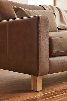 Detail view of Pierson leather sofa with white oak wood foot. 