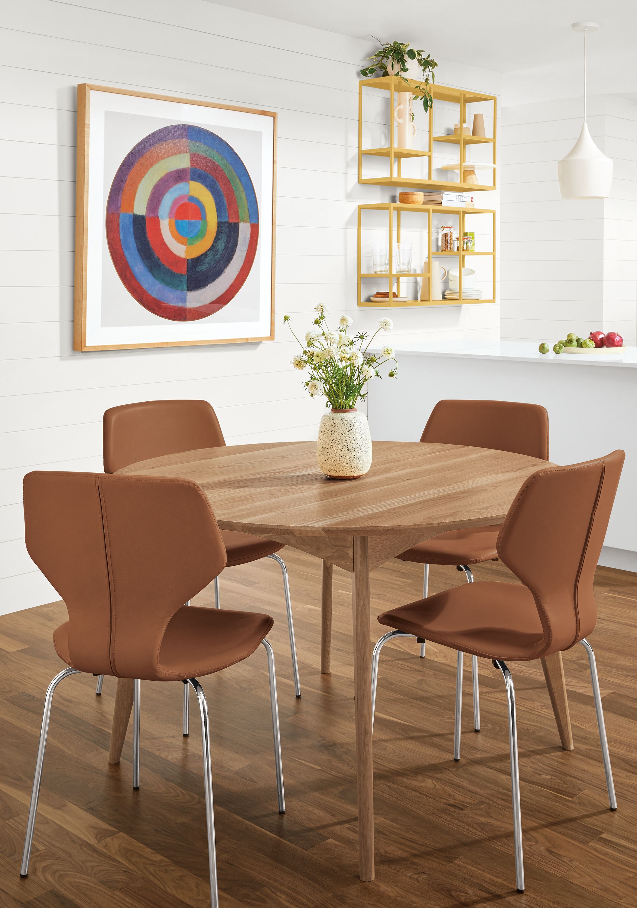 Dining area with Pike side chairs in Nola Brown leather and a Ventura round dining table in Rye.