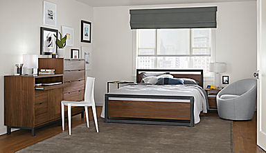 Detail of Piper queen bed in bedroom with walnut panels and natural steel frame.
