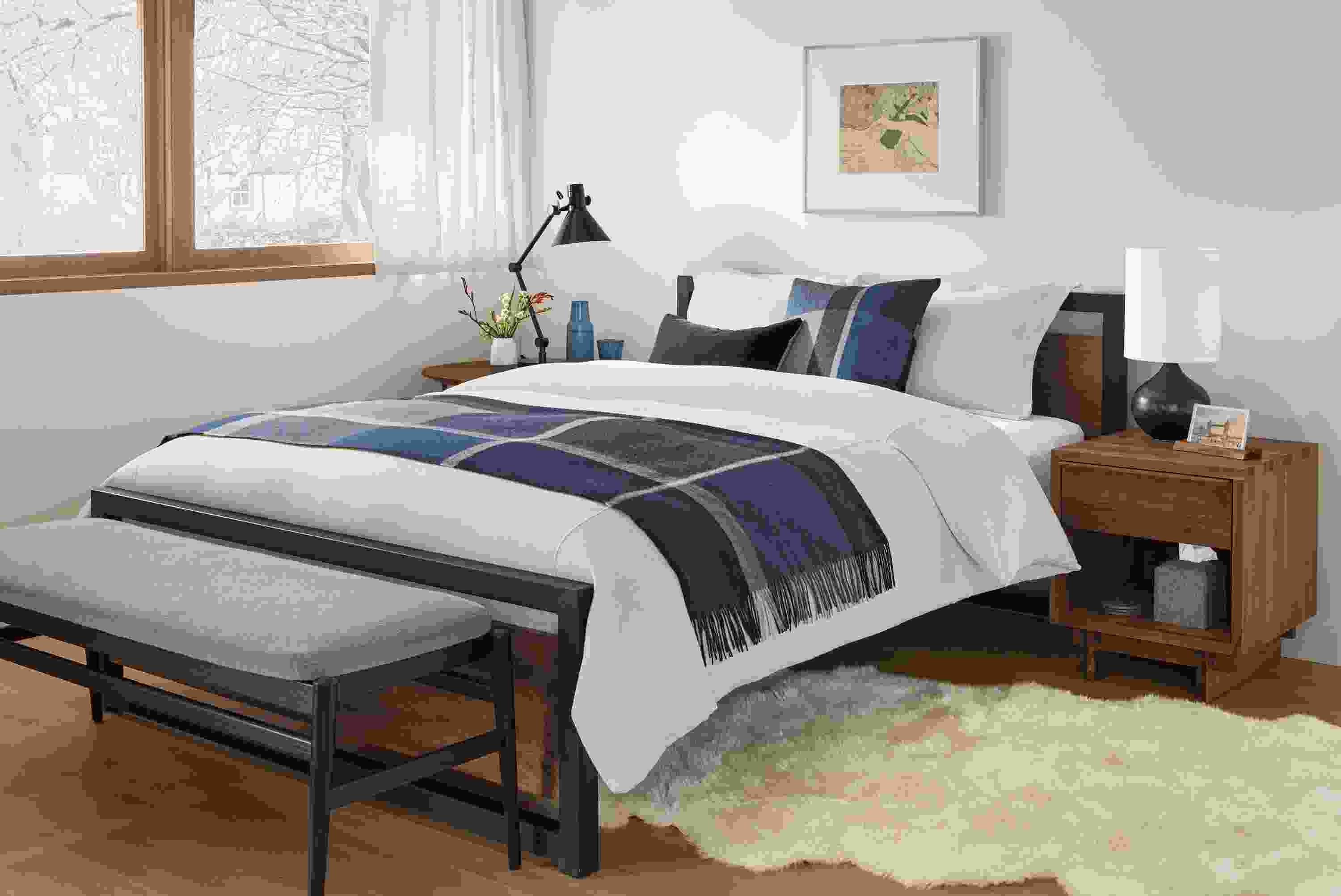 Detail of Piper queen bed in natural steel with walnut panels in small bedroom.