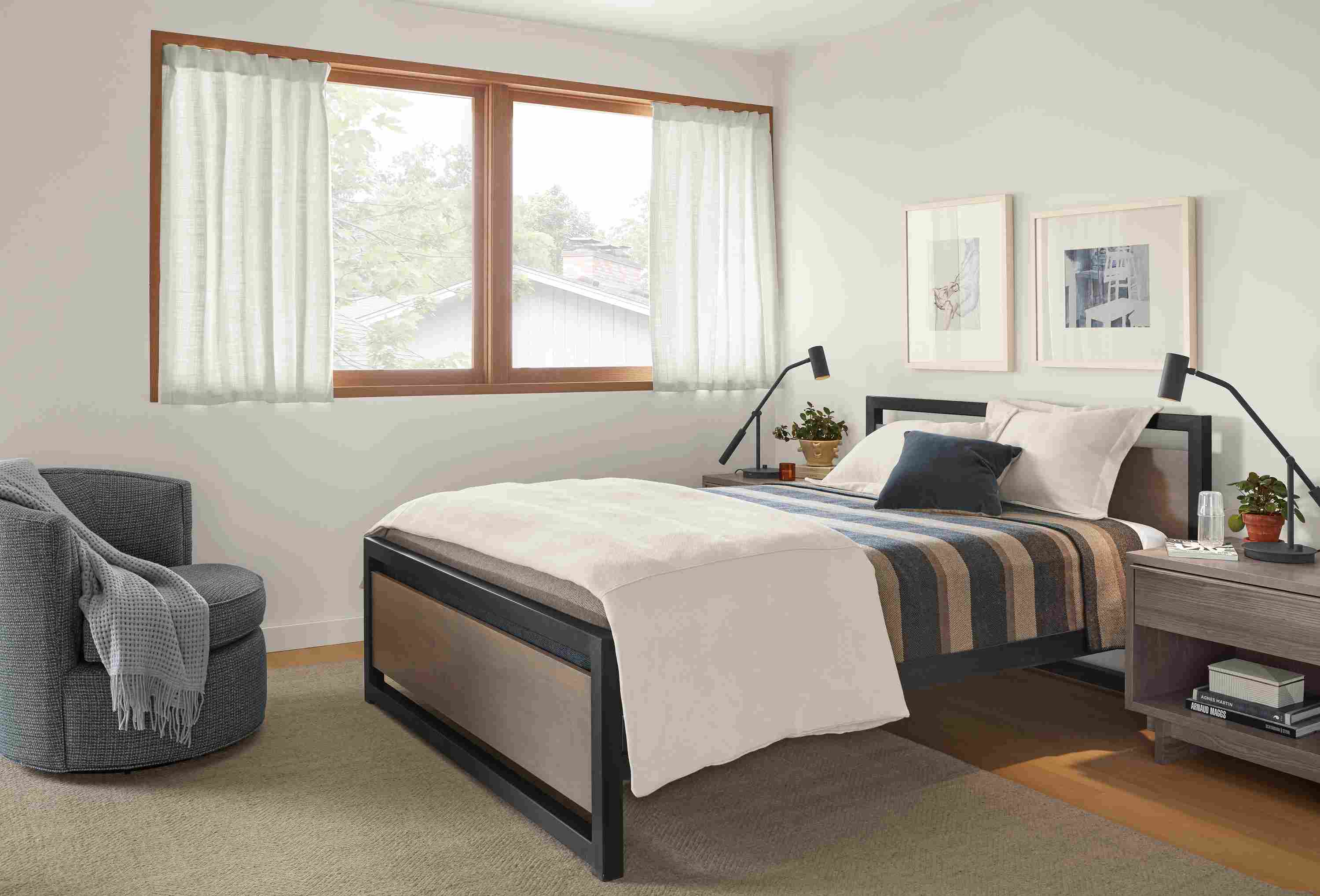 Detail of Piper queen bed in small bedroom with Otis swivel chair.