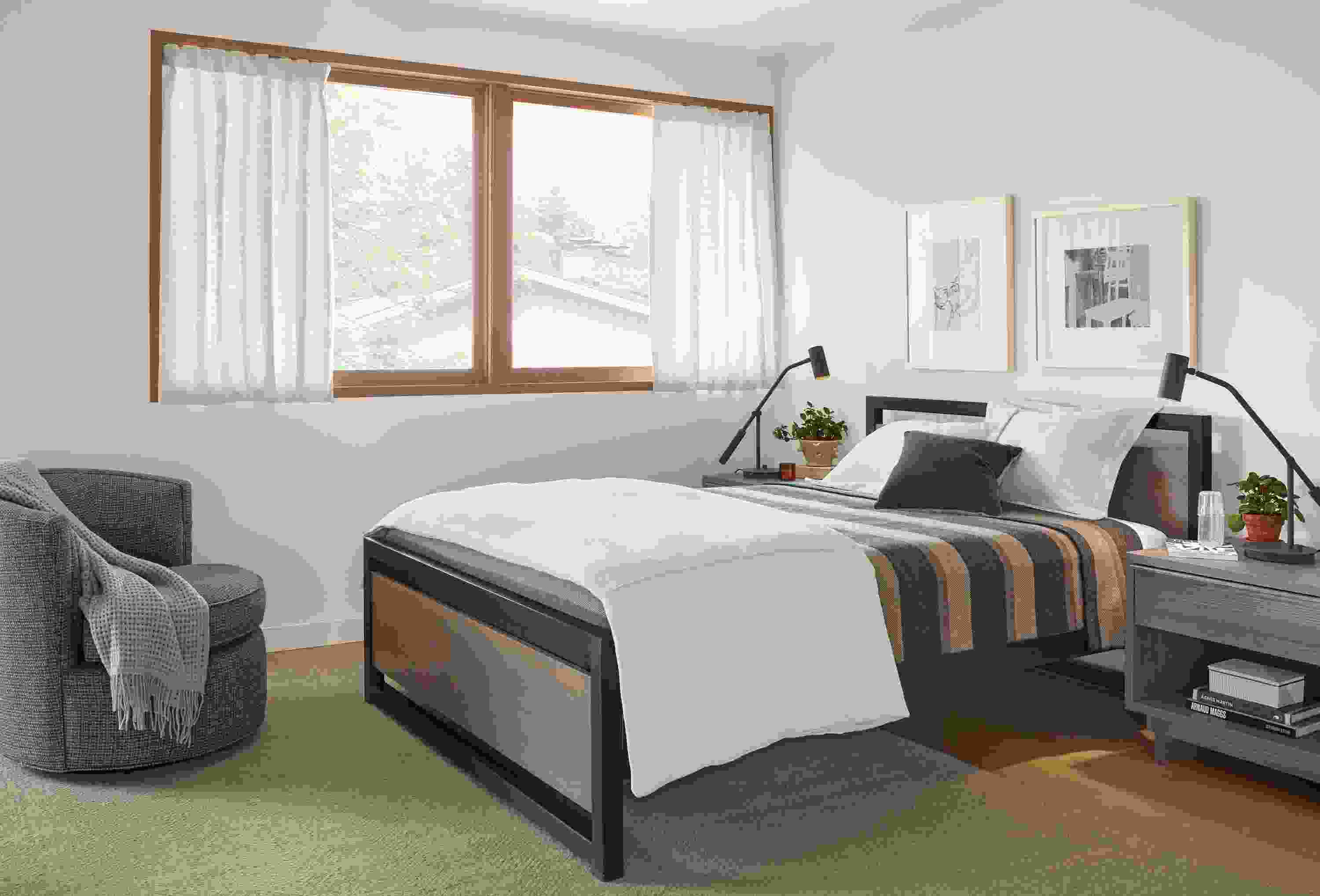 Detail of Piper queen bed in small bedroom with Otis swivel chair.