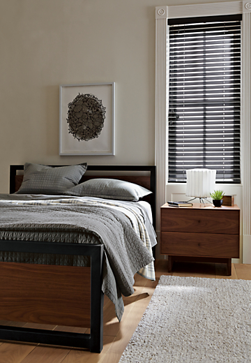 Bedroom setting with Piper bed with wood panels in walnut with hudson nightstand. 