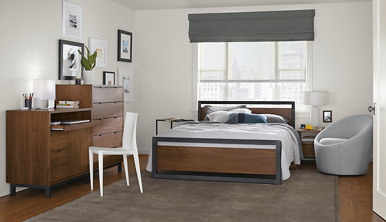 Detail of Piper queen bed in bedroom with walnut panels and natural steel frame.