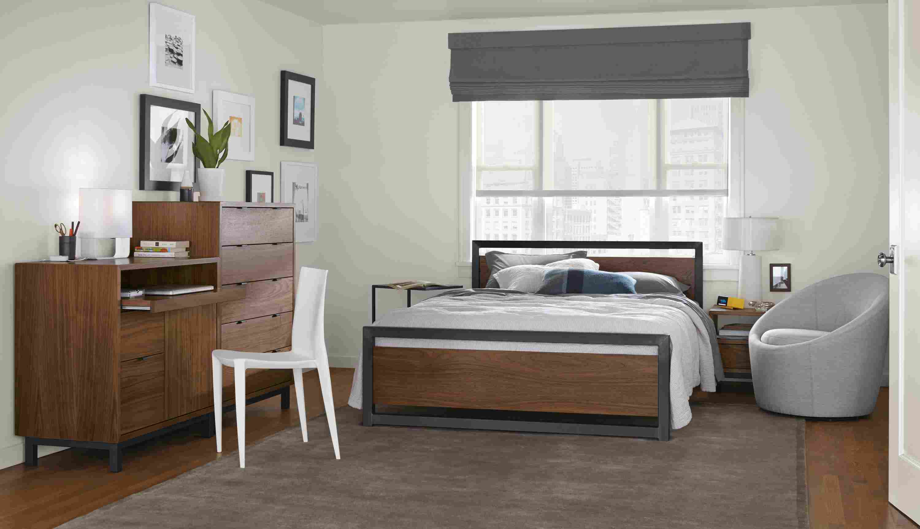 Detail of Piper queen bed in bedroom with walnut panels and natural steel frame.