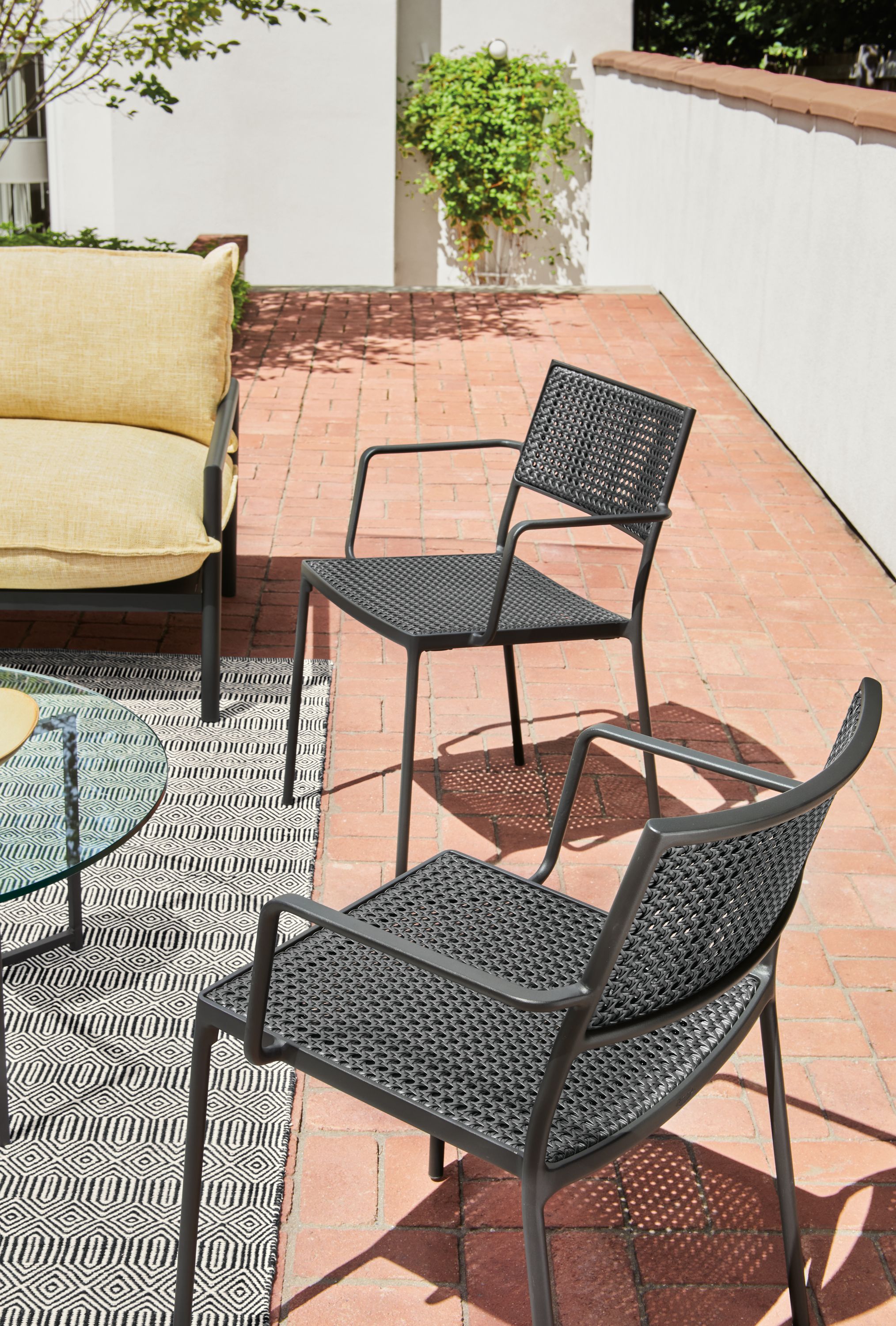 Outdoor setting with Plat chair in black with graphite frame.