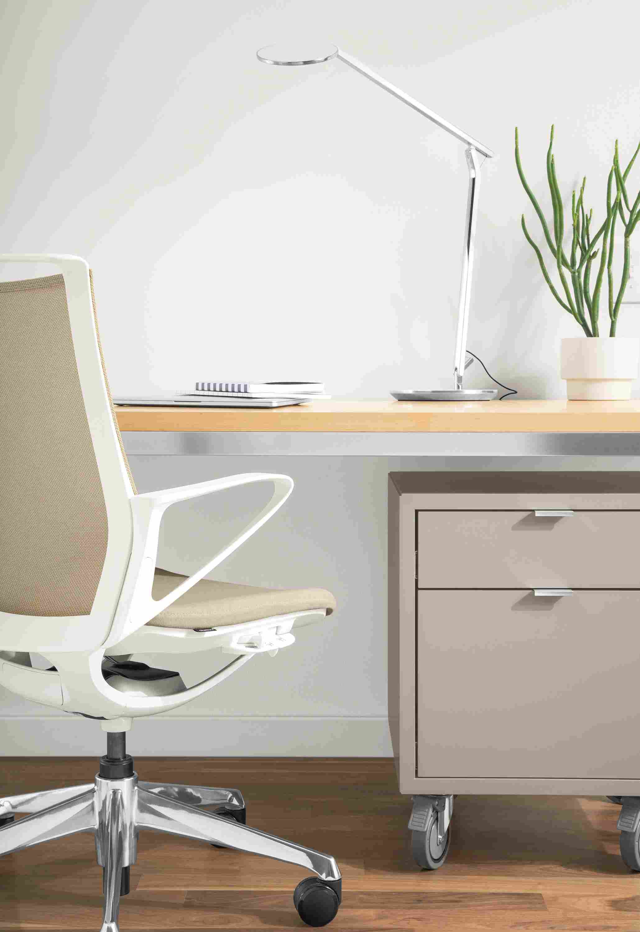 Detail of Plimode office chair at Parsons stainless steel table in home office.