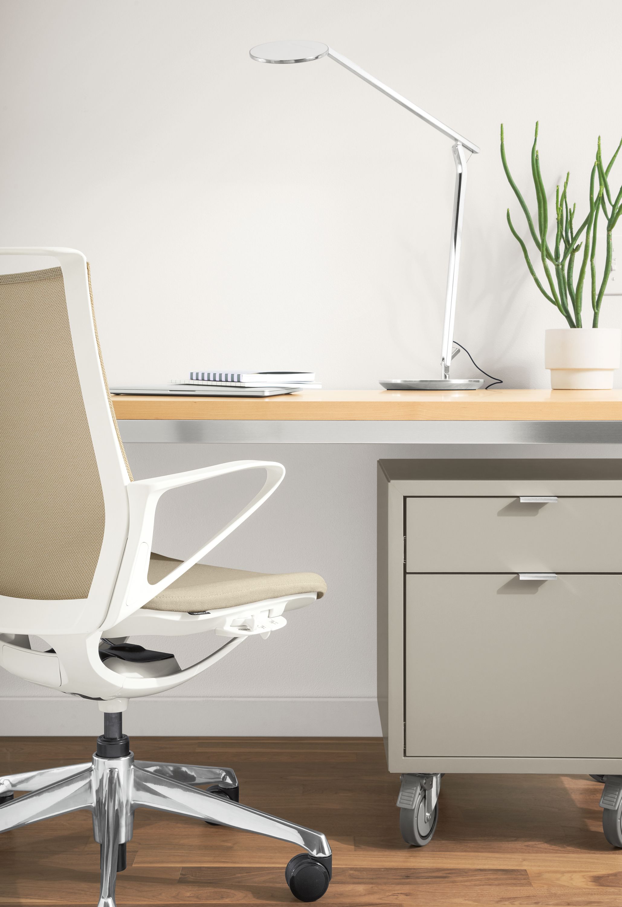 Detail of Plimode office chair at Parsons stainless steel table in home office.