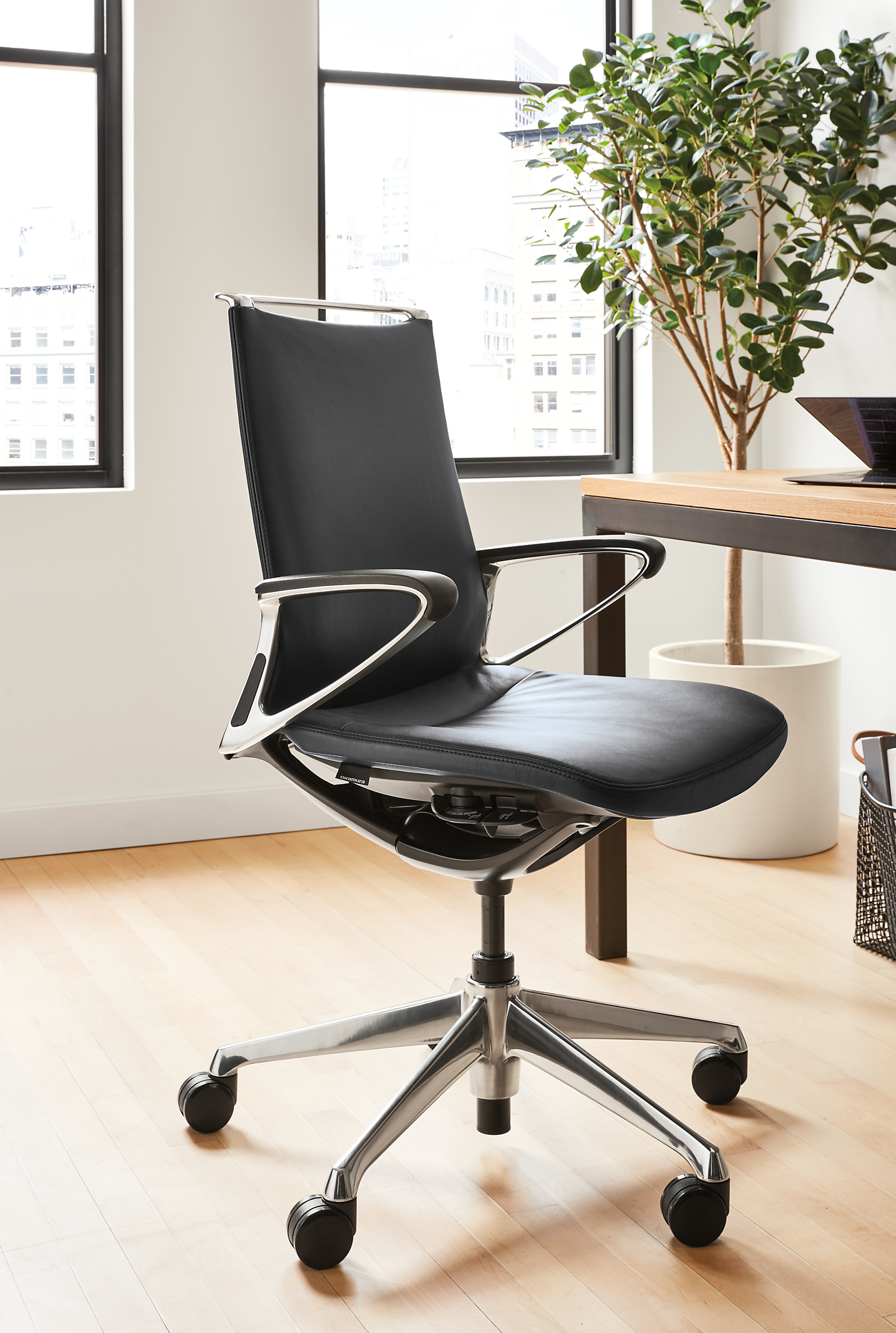 Office setting with Plimode office chair in polished aluminum with black leather.
