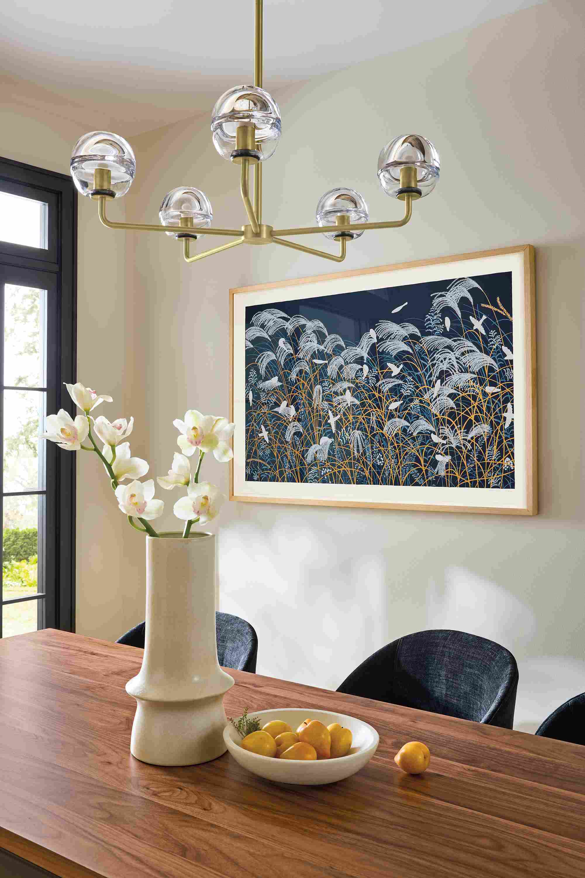 Dining room with Polar 5-globe chandelier in brushed gold powdercoat and clear glass and Niiya framed wall art.