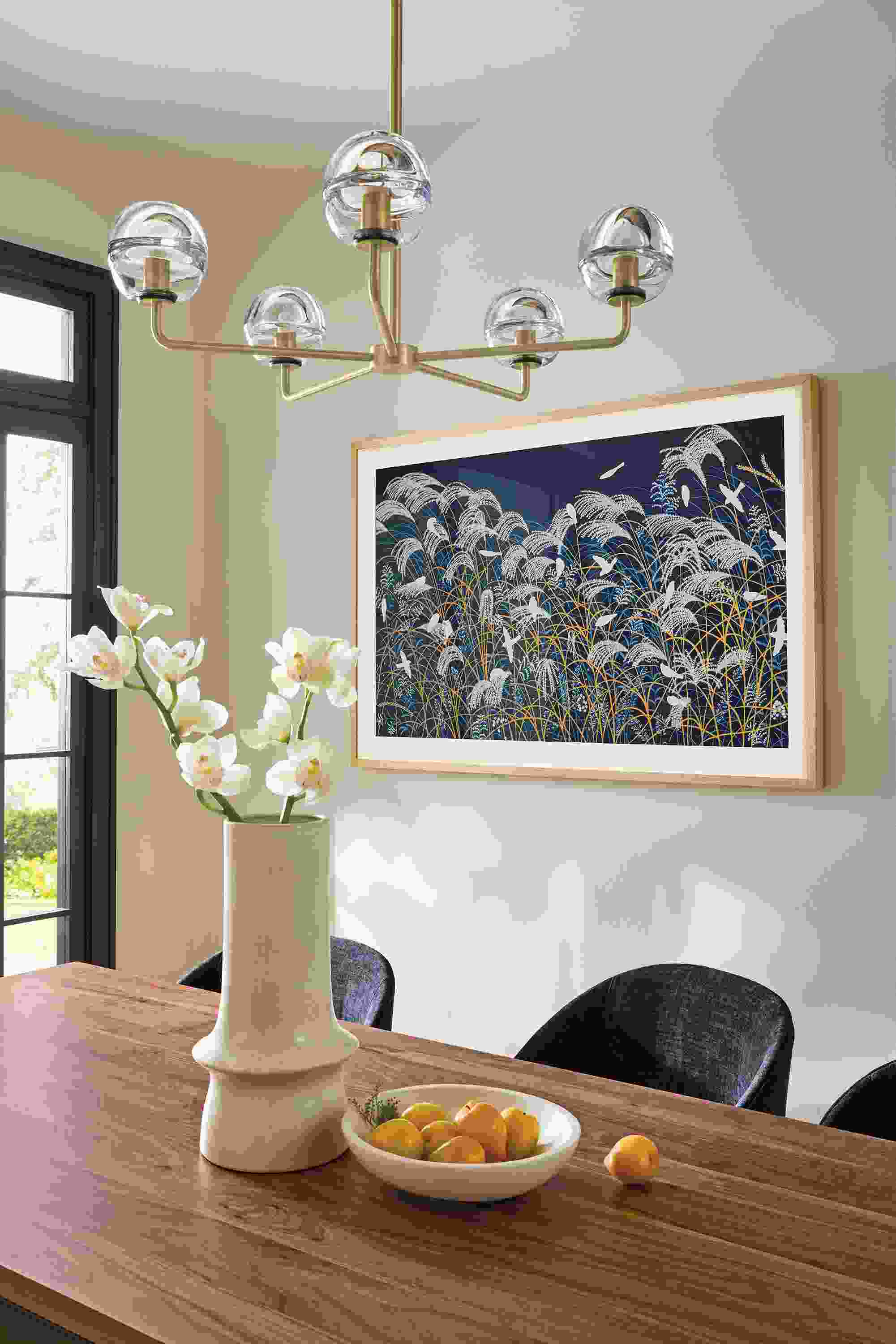 Dining room with Polar 5-globe chandelier in brushed gold powdercoat and clear glass and Niiya framed wall art.