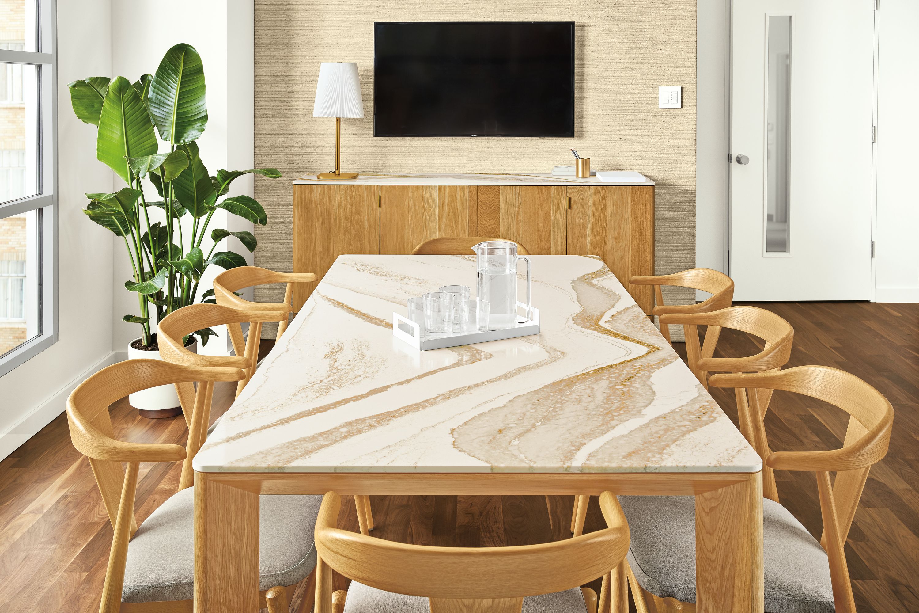 Detail of Pren dining table and console table both in white oak with Cambria Brittanica Gold tops in conference room.