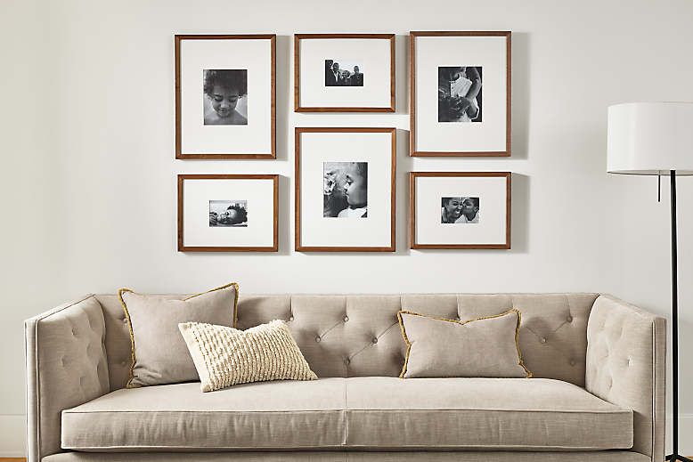detail of profile picture frame set hung above sofa