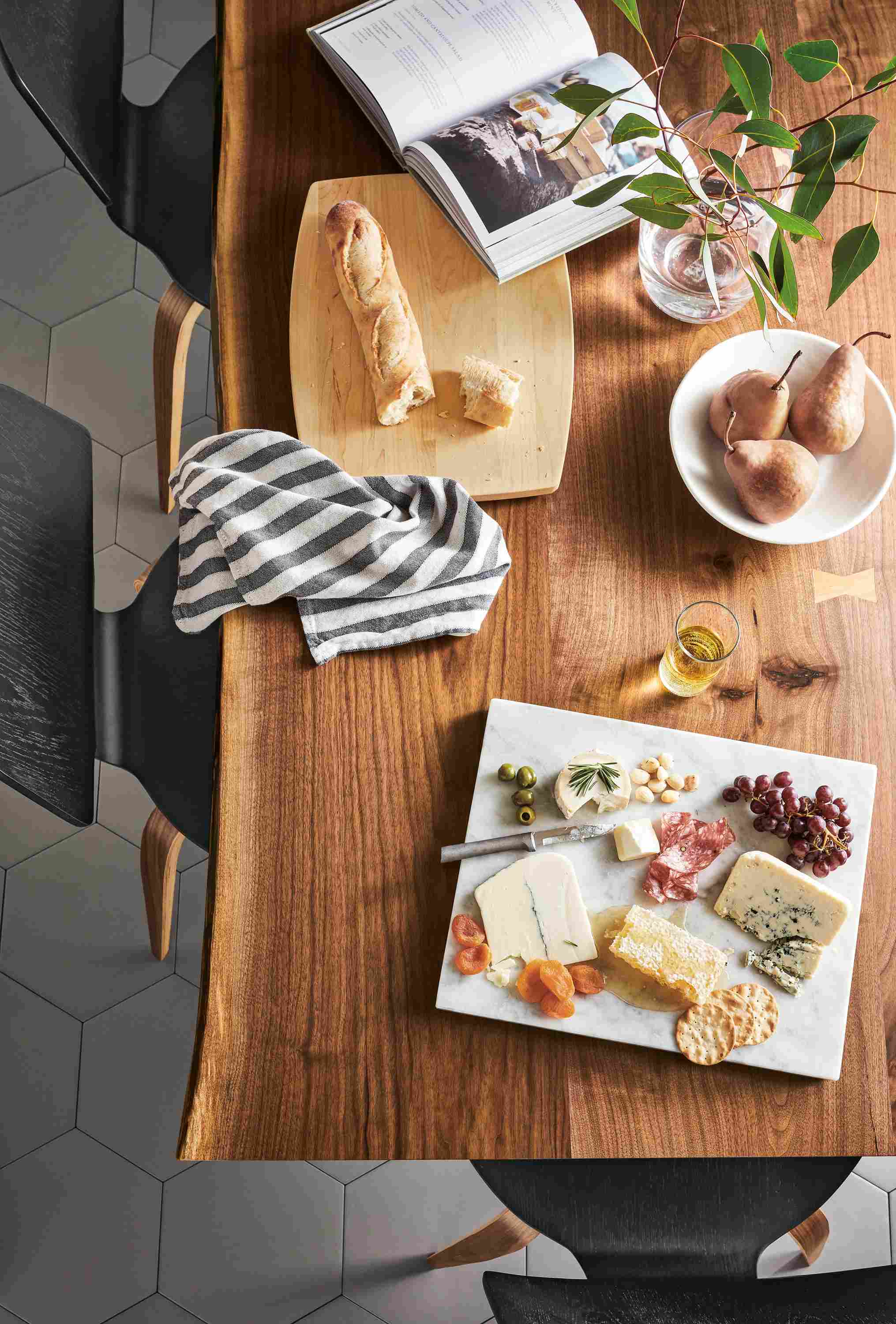 Overhead view of Quarry serving board in Venatino white marble on a Chilton 84-wide table in walnut.
