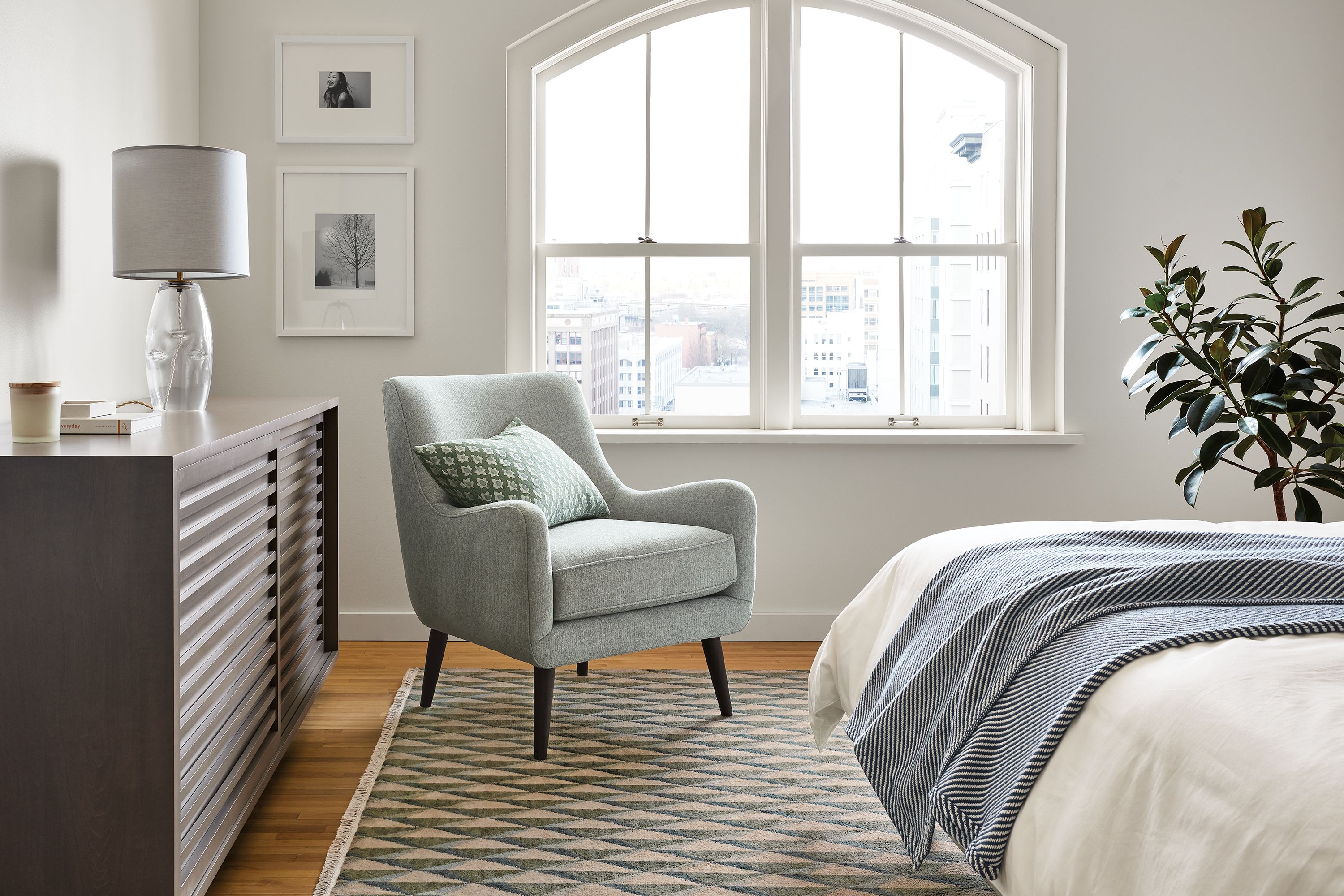 Bedroom setting with Quinn Chair in Hawkins Cadet, Moro 72-wide Storage Cabinet in charcoal and Plaza Rug in Green and Slate.