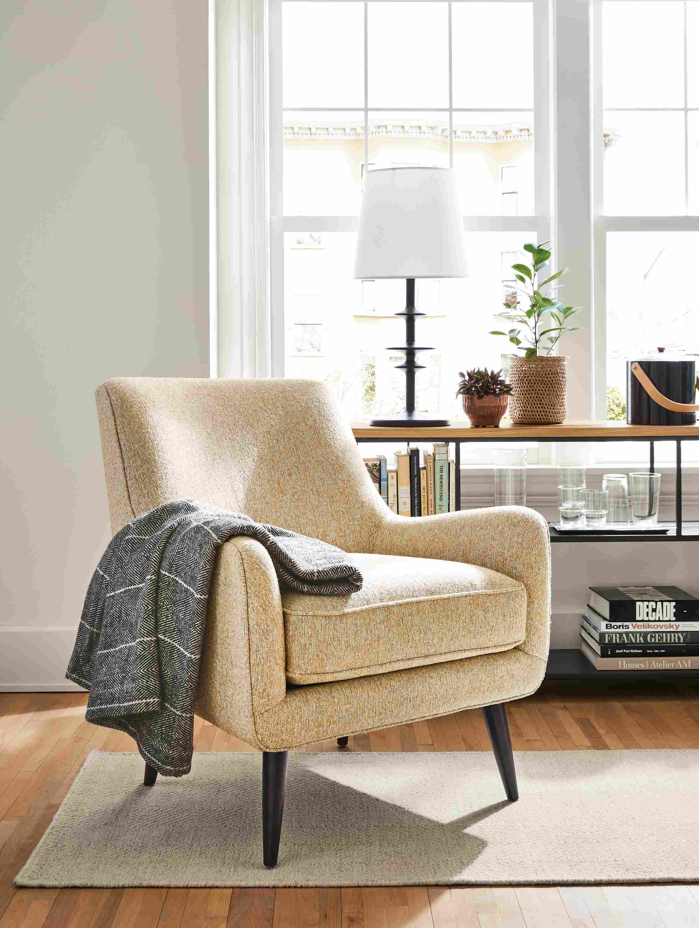 Living room with Quinn chair in Conley saffron and Avilia rug in heather.