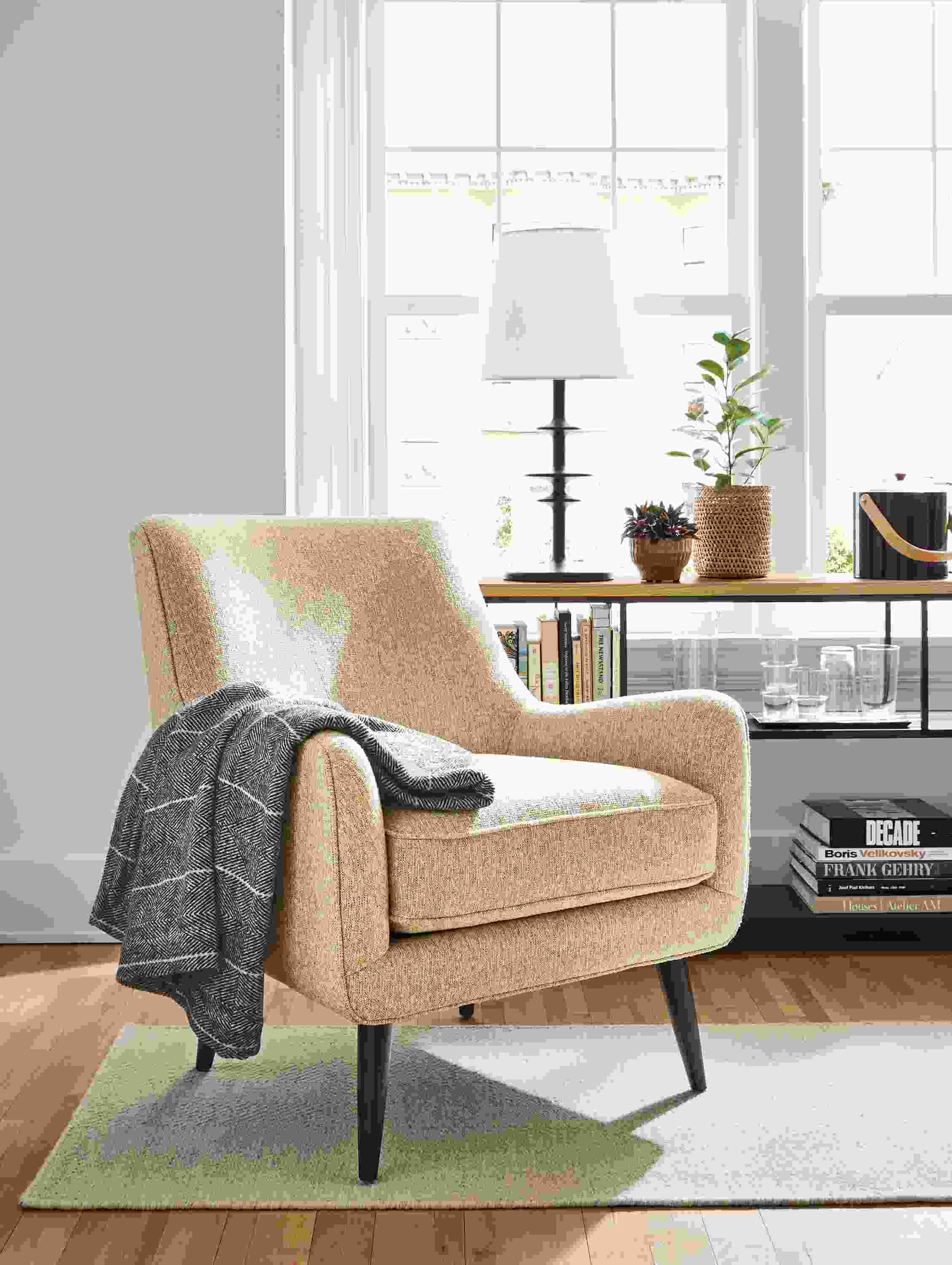 Living room with Quinn chair in Conley saffron and Avilia rug in heather.