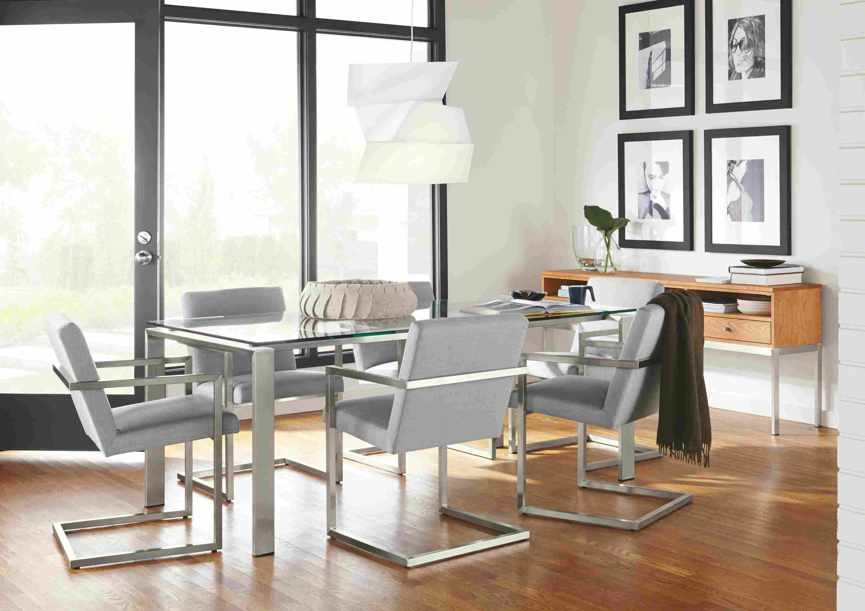 Dining room setting with Rand 72-wide by 36 table in Stainless steel with clear glass top.