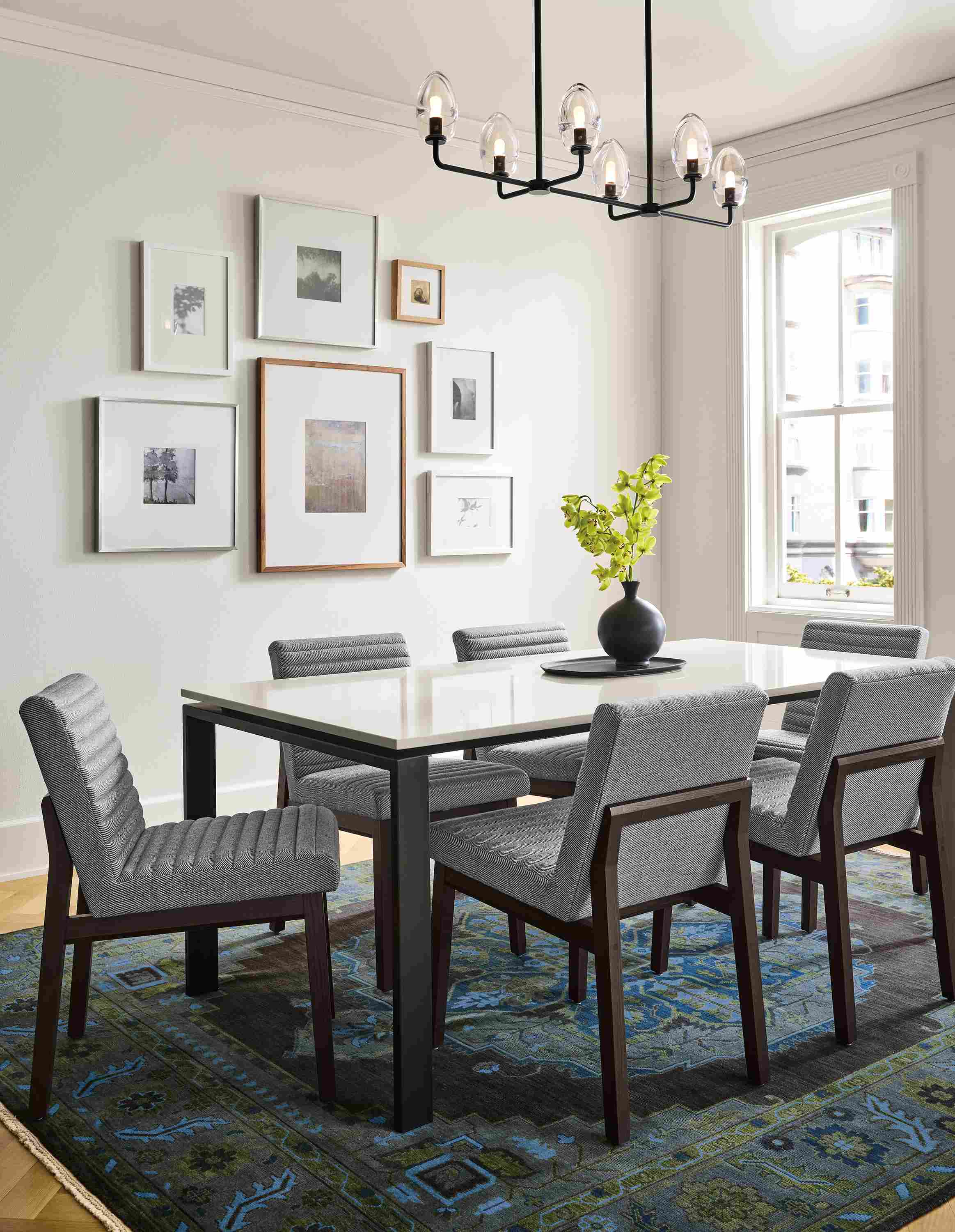 Dining area with rand 72 by 36 table in natural steel with light grey quartz and 6 olsen side chairs in Derry Graphite and Charcoal legs.