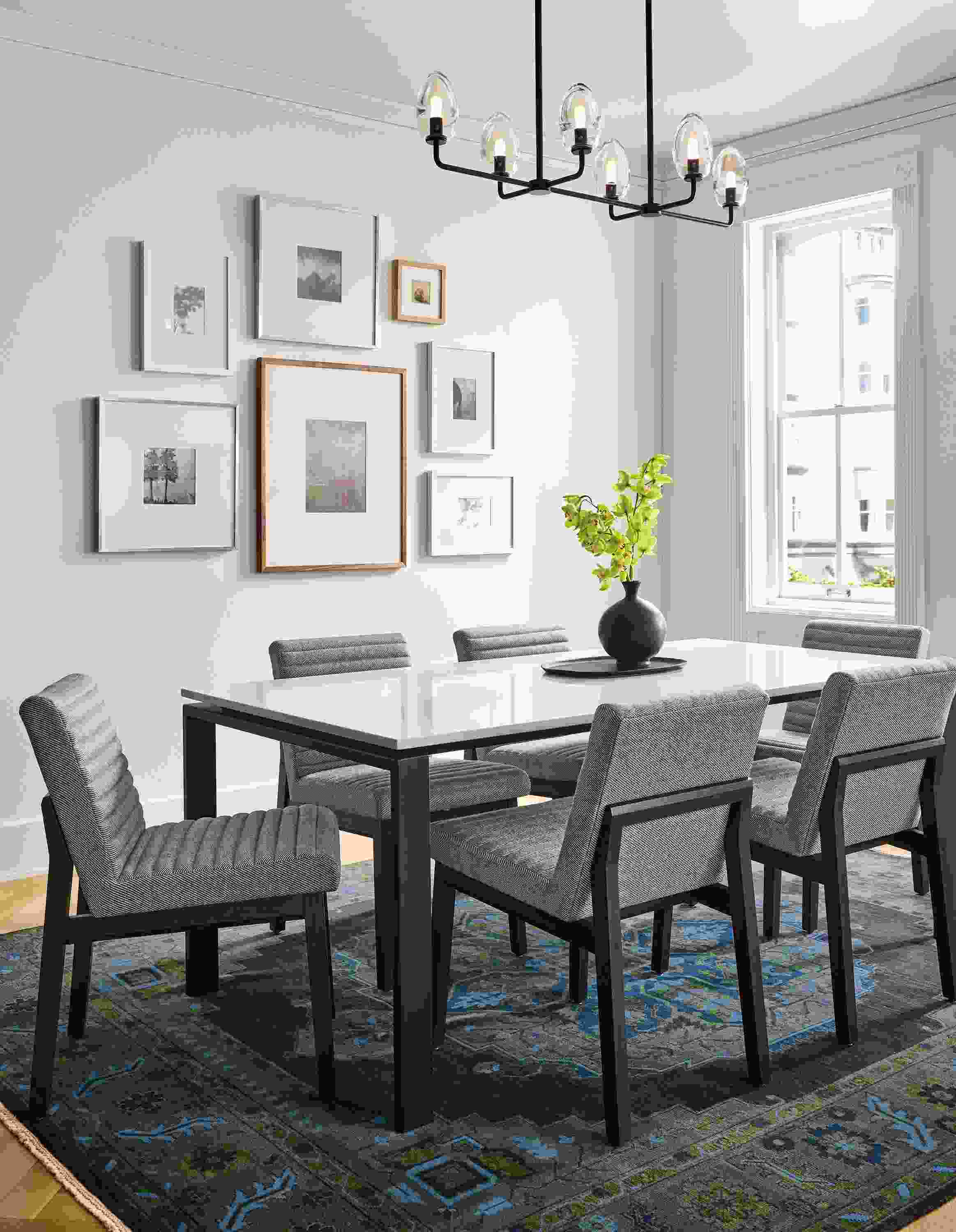 Dining area with rand 72 by 36 table in natural steel with light grey quartz and 6 olsen side chairs in Derry Graphite and Charcoal legs.