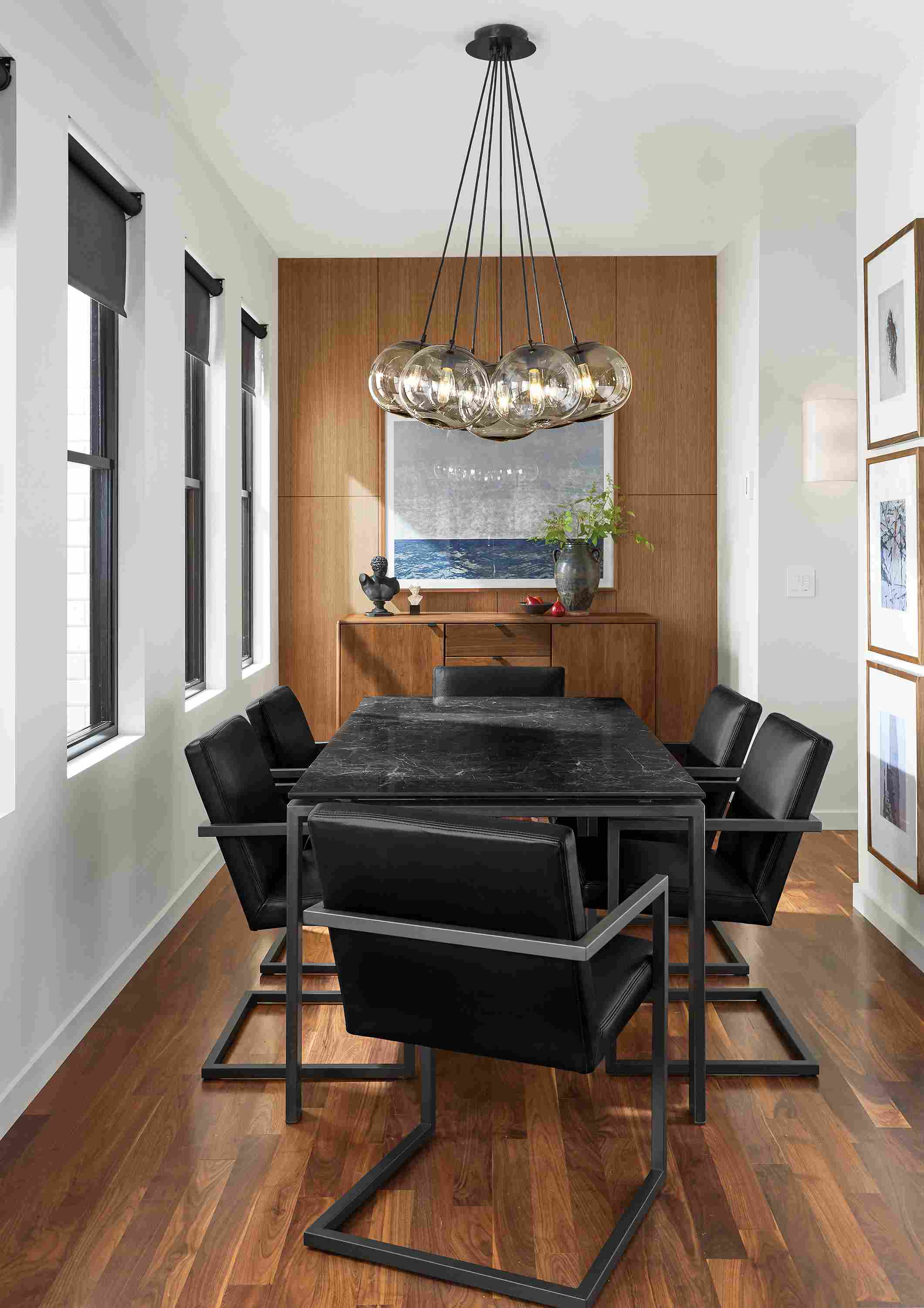 Room with rand table in natural steel, 6 lira arm chairs in pesaro black leather and meara wall sconce.