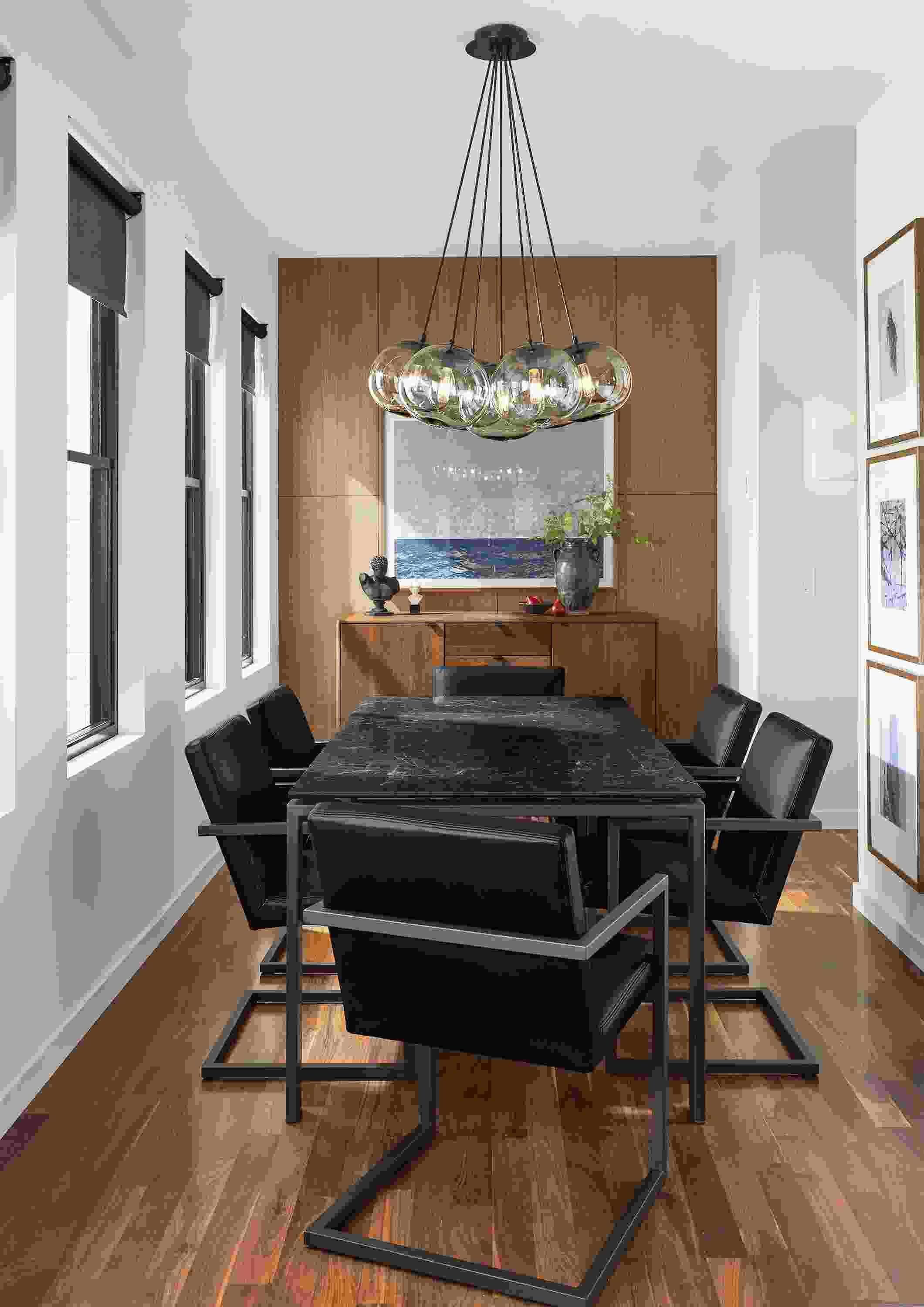 Room with rand table in natural steel, 6 lira arm chairs in pesaro black leather and meara wall sconce.