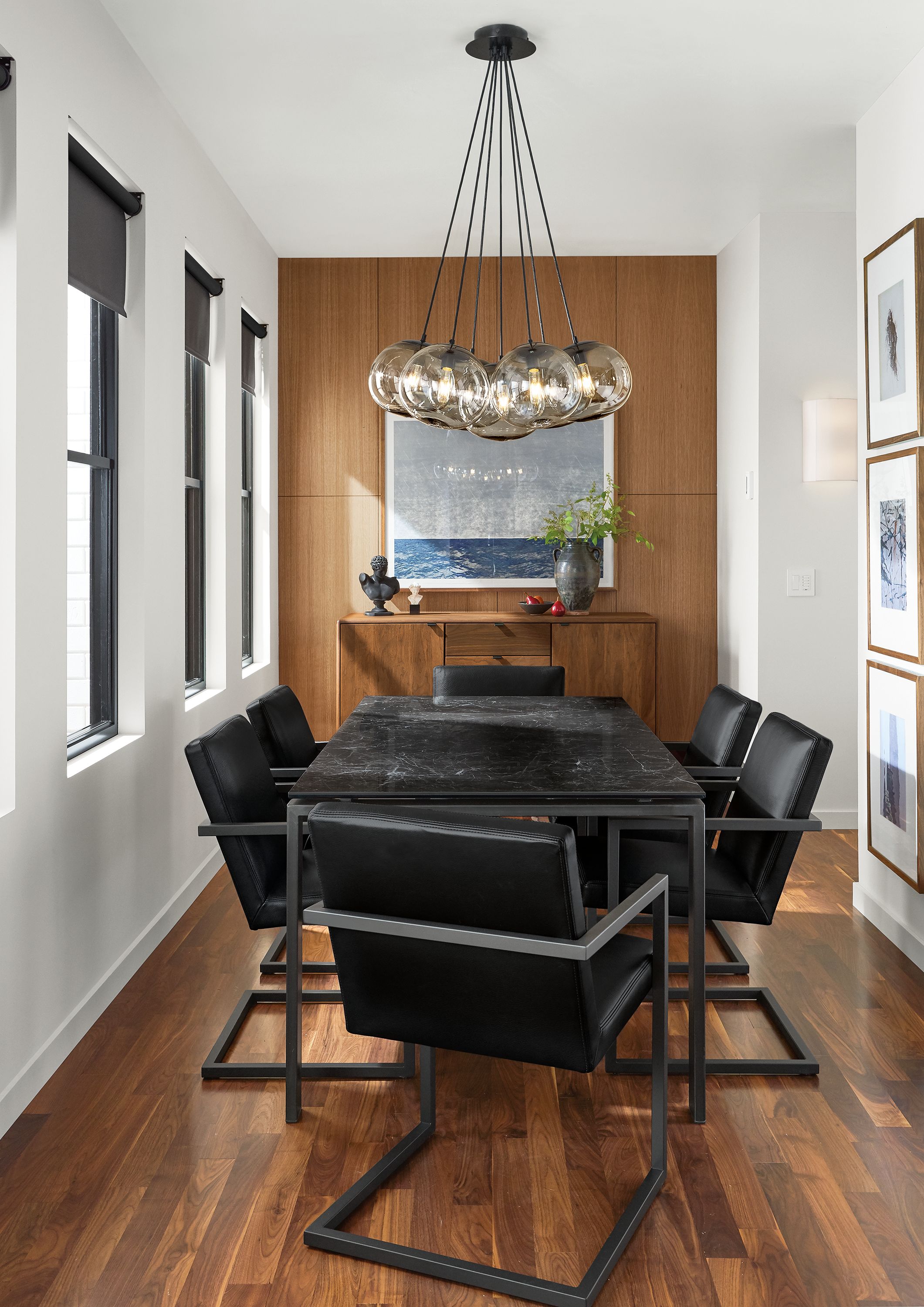 Room with rand table in natural steel, 6 lira arm chairs in pesaro black leather and meara wall sconce.