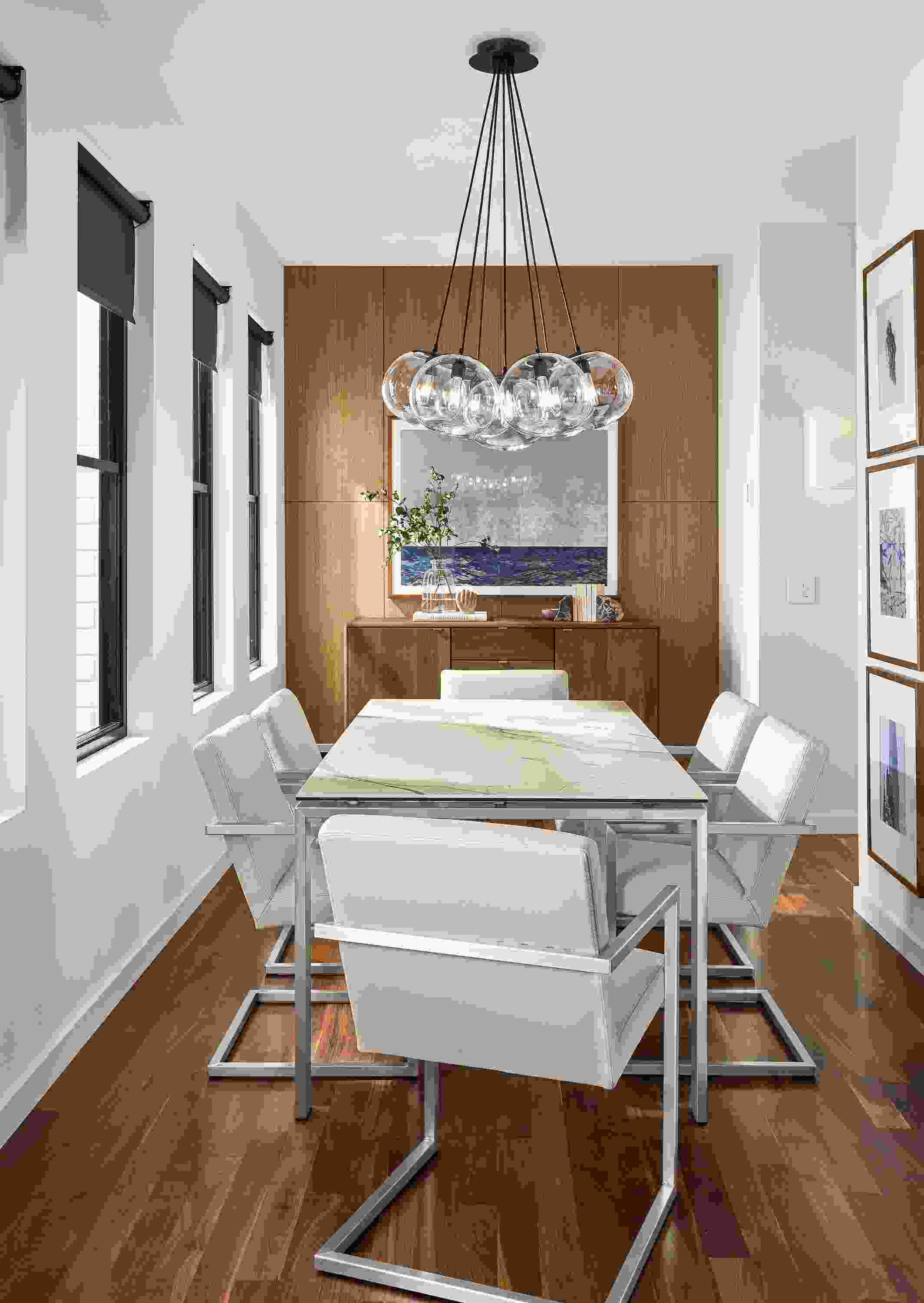 Dining room Rand table in stainless and white marbled ceramic and Humboldt 7-globe chandelier.