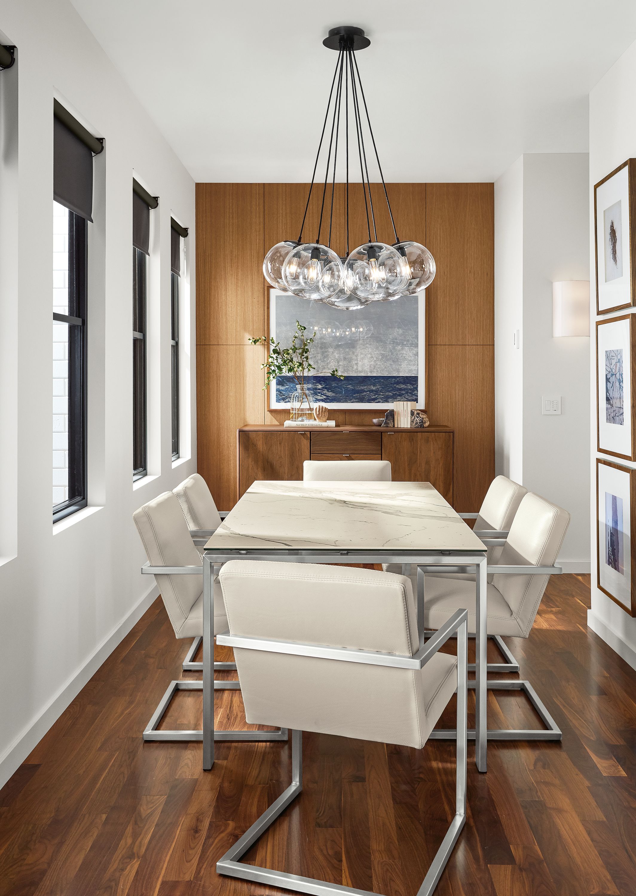 Dining room Rand table in stainless and white marbled ceramic and Humboldt 7-globe chandelier.