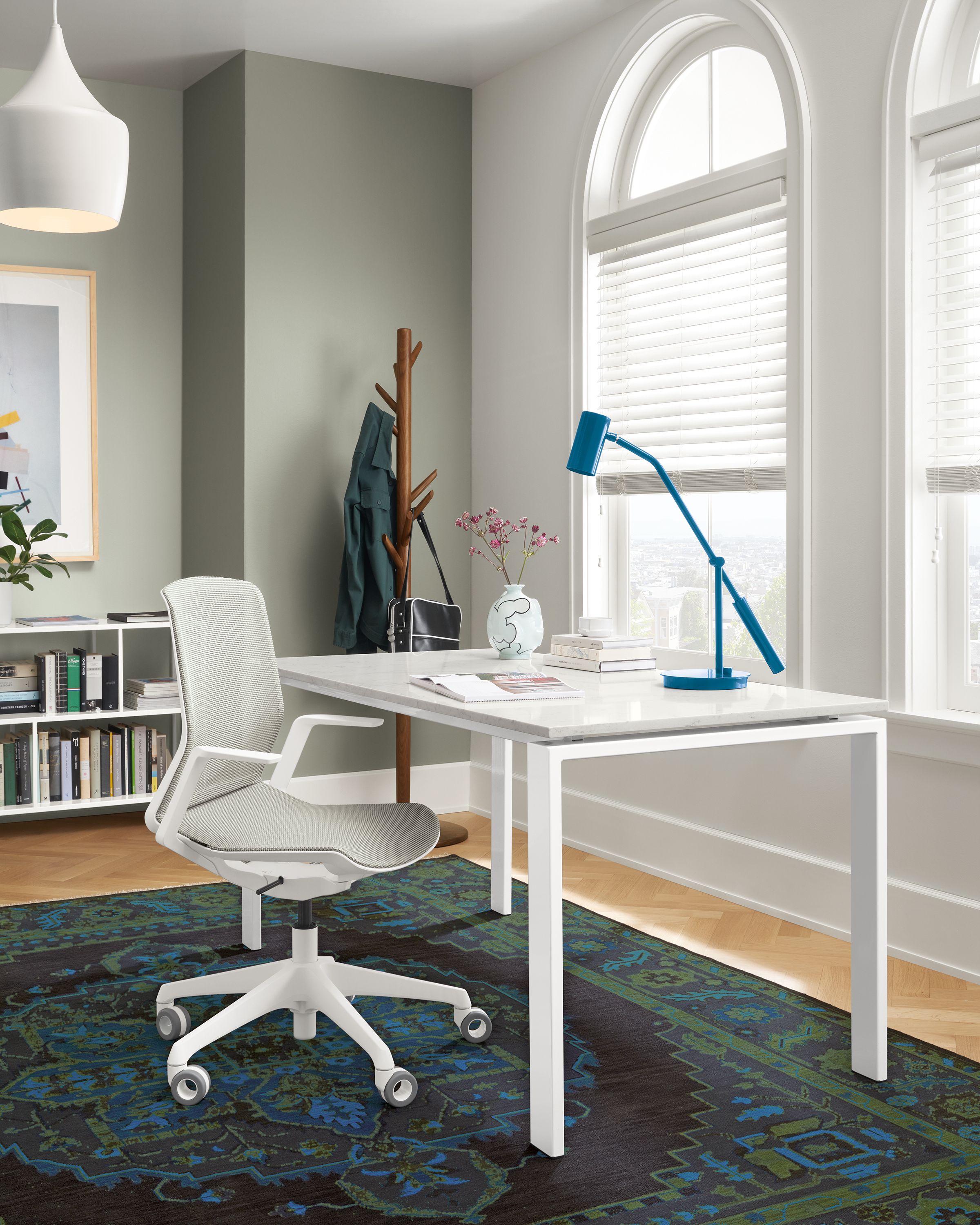 office with rand table with white base, cynara office chair, heriz rug.