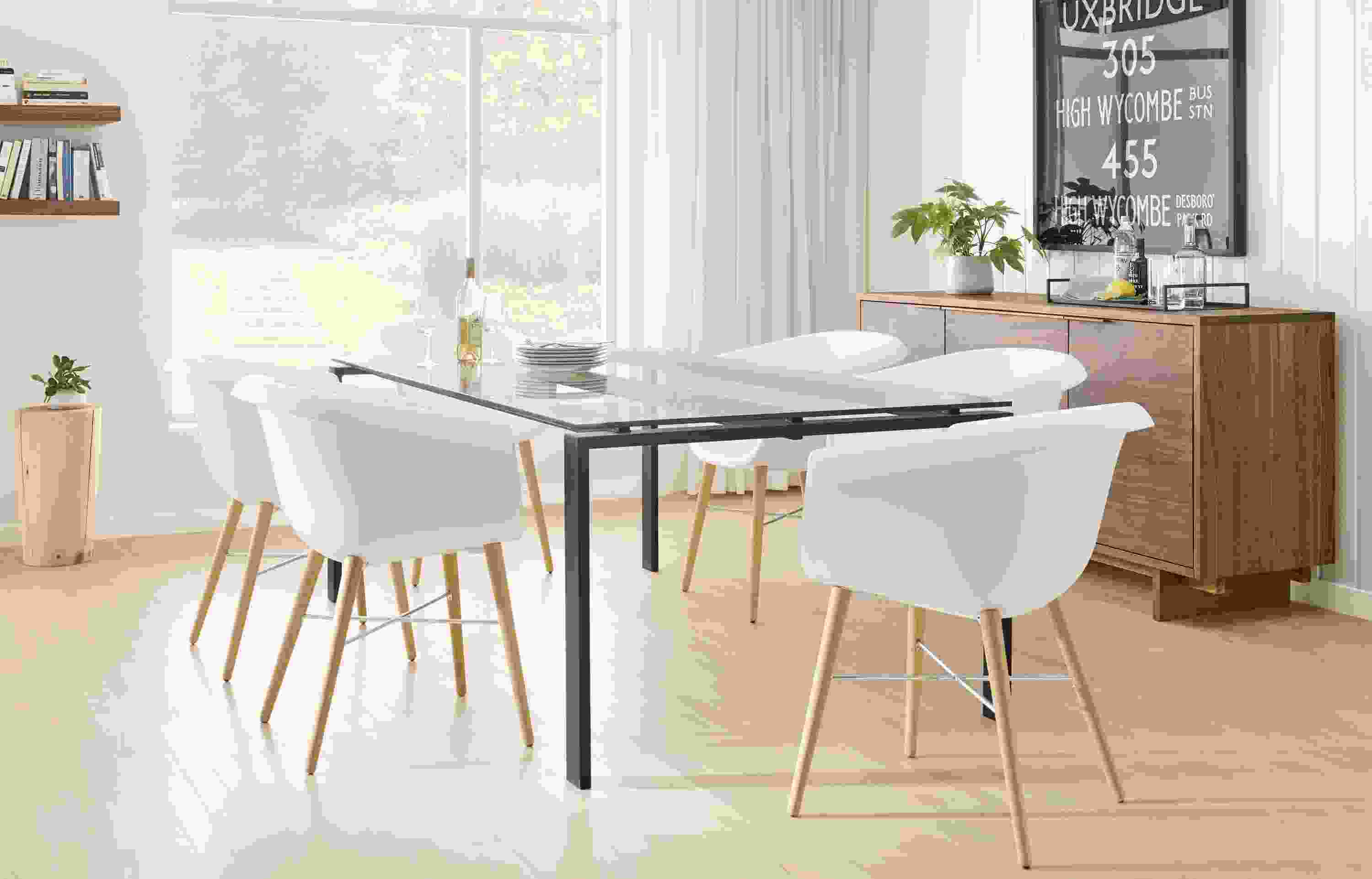 Detail of Rand dining table with natural steel base and clear glass top.